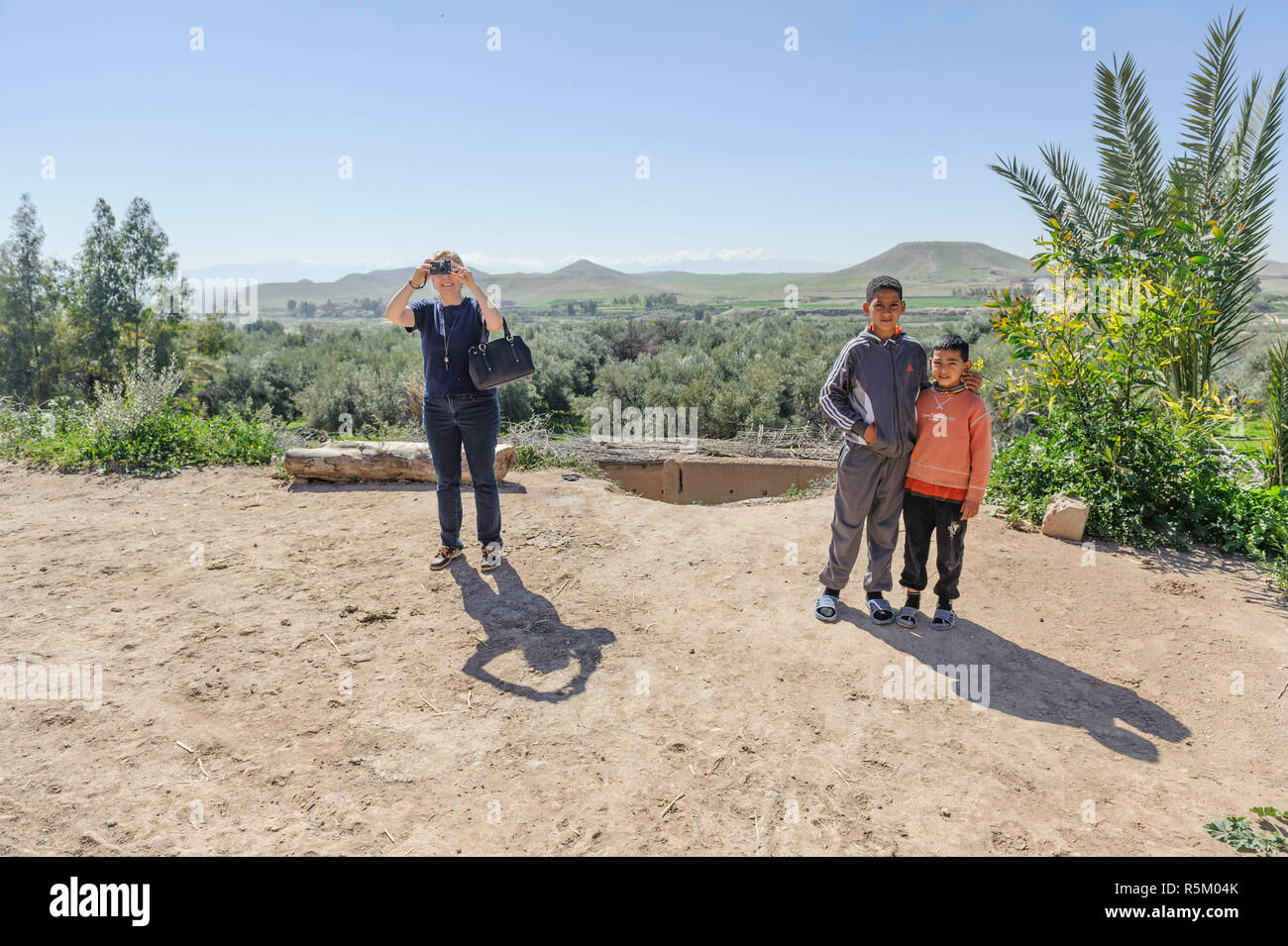 01-03-15, Marrakesch, Marokko. Zwei junge Berber Jungen stehen und Stellen in der Nähe von Touristen fotografieren auf einem iPhone. Foto: © Simon Grosset Stockfoto