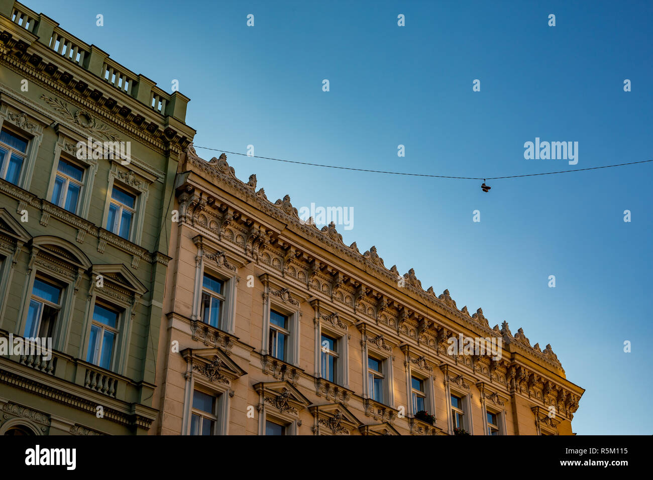 Gegenüberstellung. Paar Turnschuhe hängen hoch über Stadt Straße in der Altstadt von Prag, der Hauptstadt der Tschechischen Republik, neben antiken Haus Stockfoto