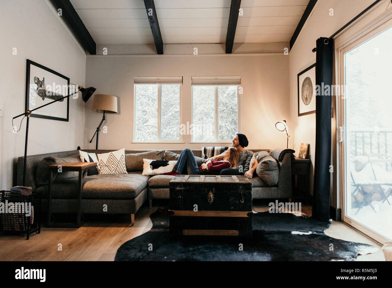 Junge attraktive kaukasische Liebespaar kuscheln sich modischen Schnitt Couch Sofa Möbel in trendigen, modernen Minimalistisch gestaltete Wohnung Wohn Stockfoto