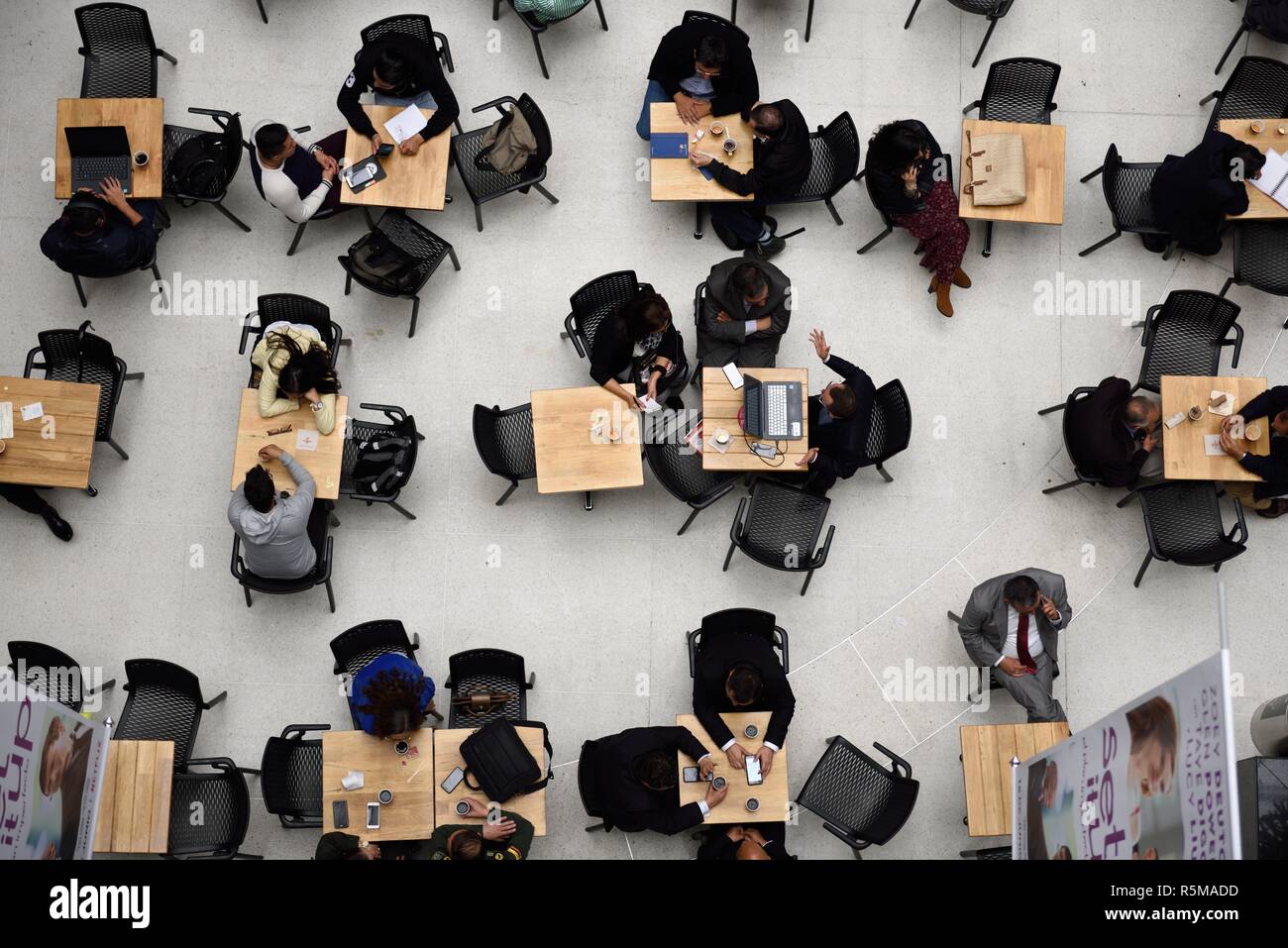 13. Juni 2018, Luftaufnahme einer Gruppe von Menschen, die an Tischen in einem Café sitzen, reden, Kaffee trinken, ihre Handys und Laptops benutzen. Stockfoto