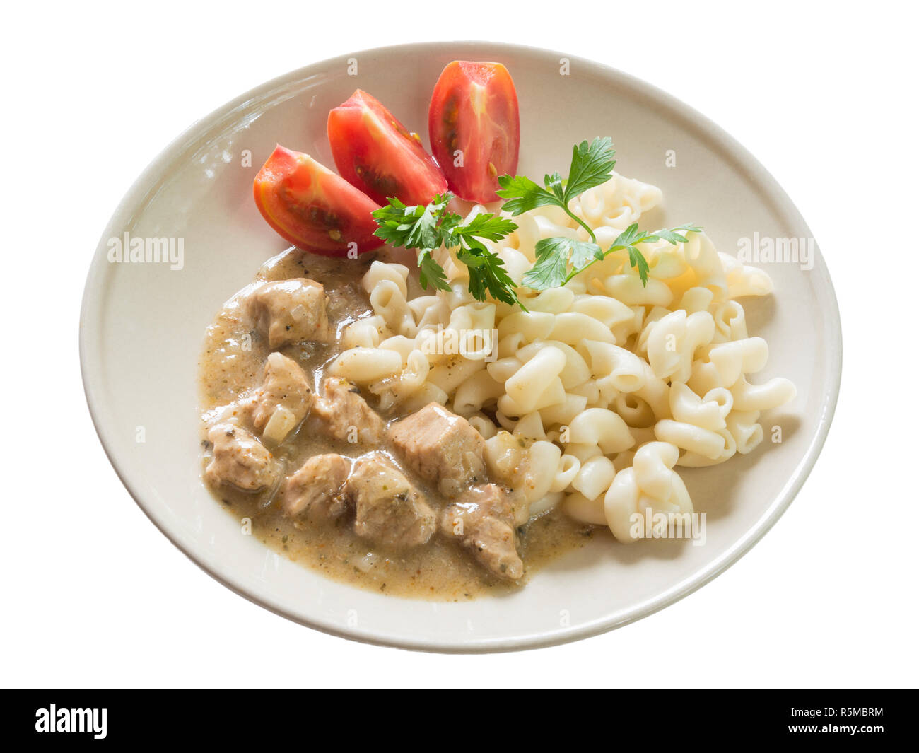 Schweinefleisch Gulasch mit Makkaroni und in Scheiben geschnittenen Tomaten, auf weißem Hintergrund Stockfoto