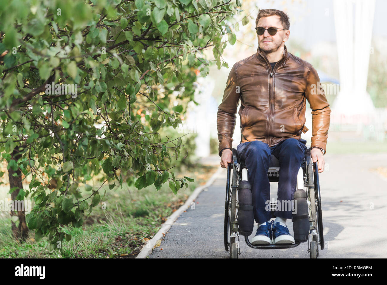 Ein junger Mann im Rollstuhl Fahrten entlang der Park Road Stockfotografie Alamy