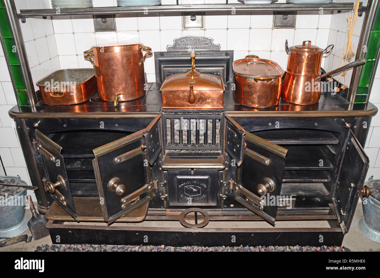Große. Antike/vintage Küche Herd mit einer Vielzahl von Kupfer Pfannen und Töpfe. Stockfoto