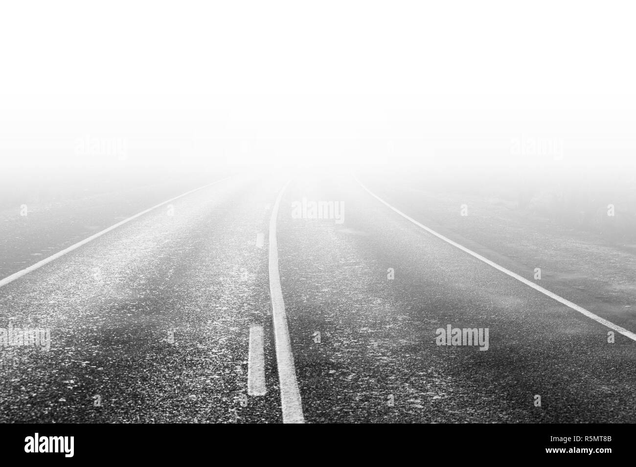 Ländliche Straße verschwinden in White Haze in Schwarz und Weiß Stockfoto