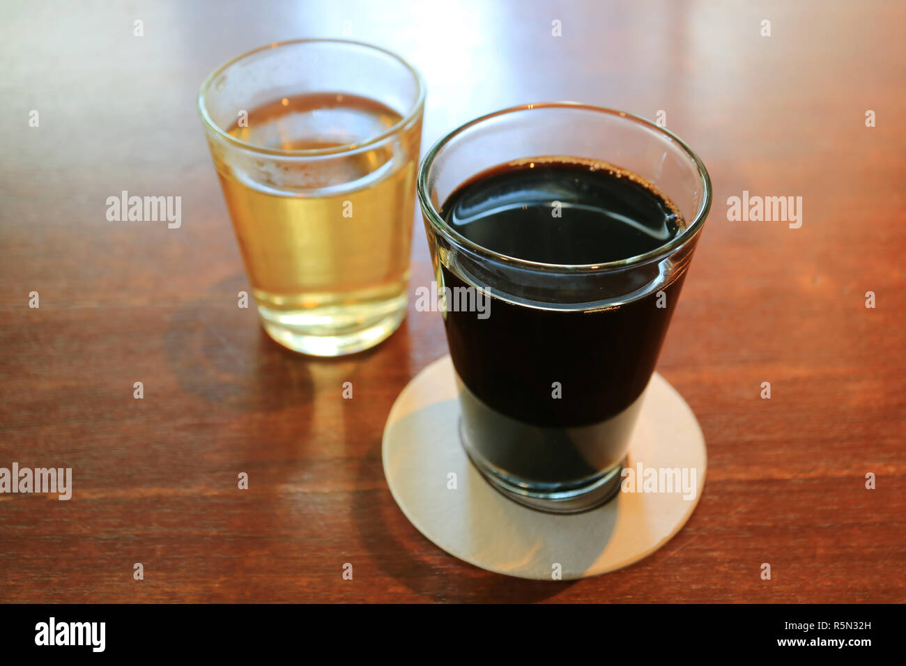 Heißer Schwarzer Kaffee und Heiße chinesischen Tee in transparenten Gläser auf hölzernen Tisch serviert Stockfoto