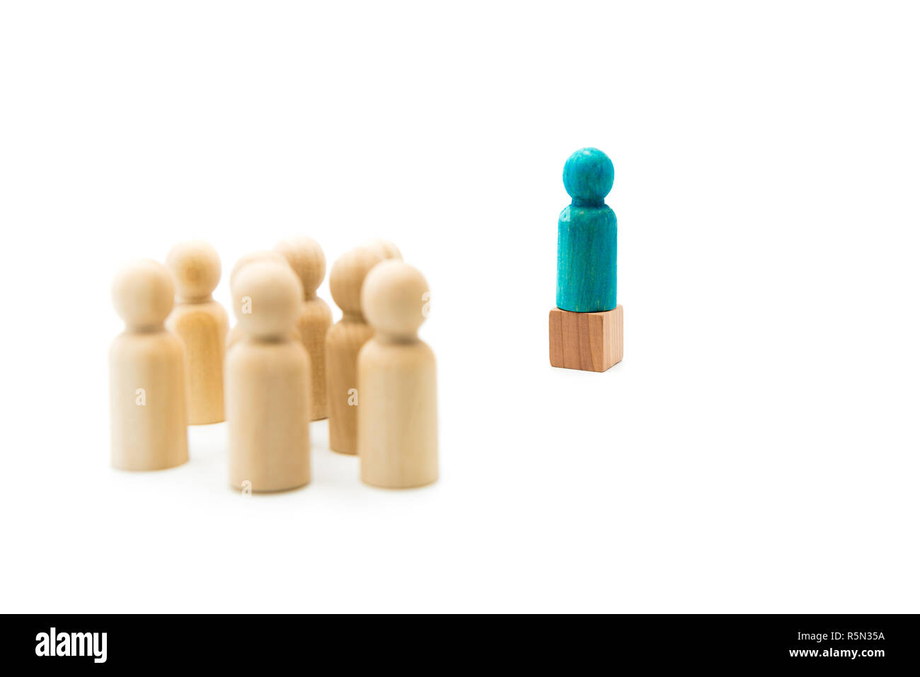 Holzfiguren als Gruppe hören auf einem blauen Abbildung helding Rede, auf weißem Hintergrund Stockfoto