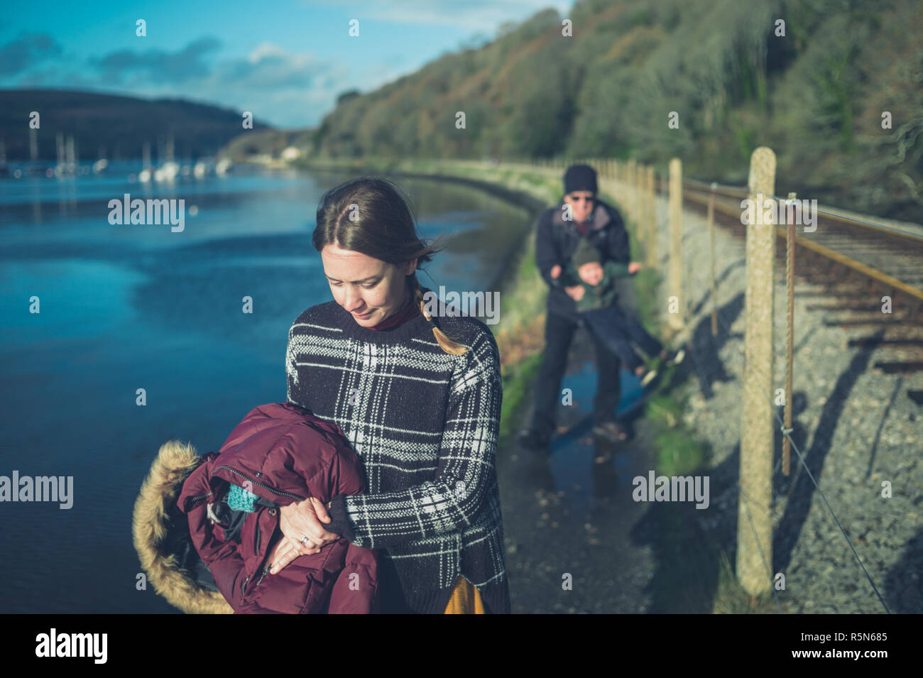 Mit mehreren Generationen Familie mit einem Kleinkind und Großvater sind zu Fuß durch die Gleise Stockfoto
