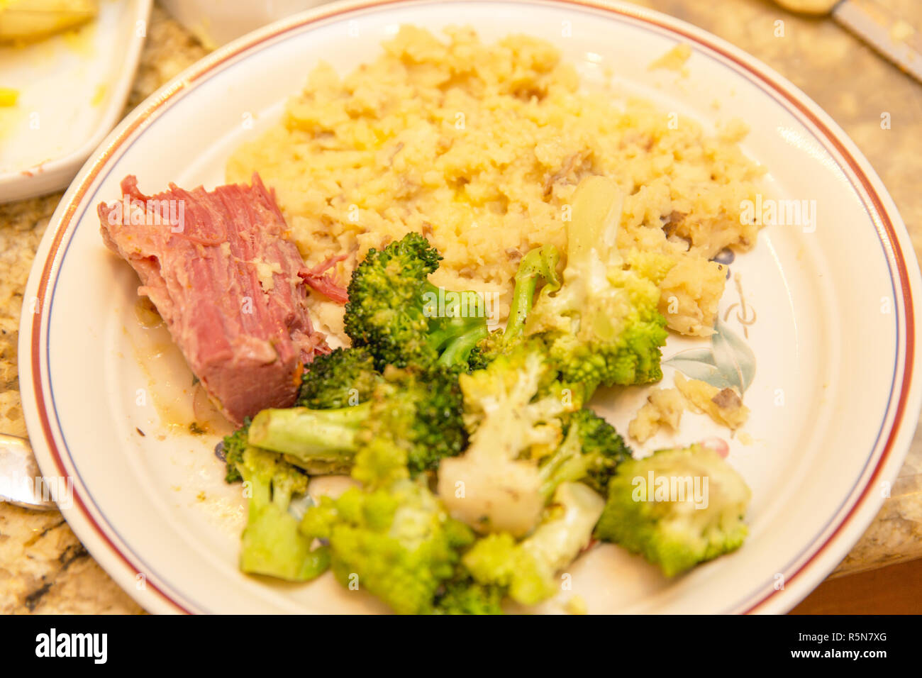 Keramikteller mit Corned beef, Brokkoli und Reis in einer Küche. Stockfoto