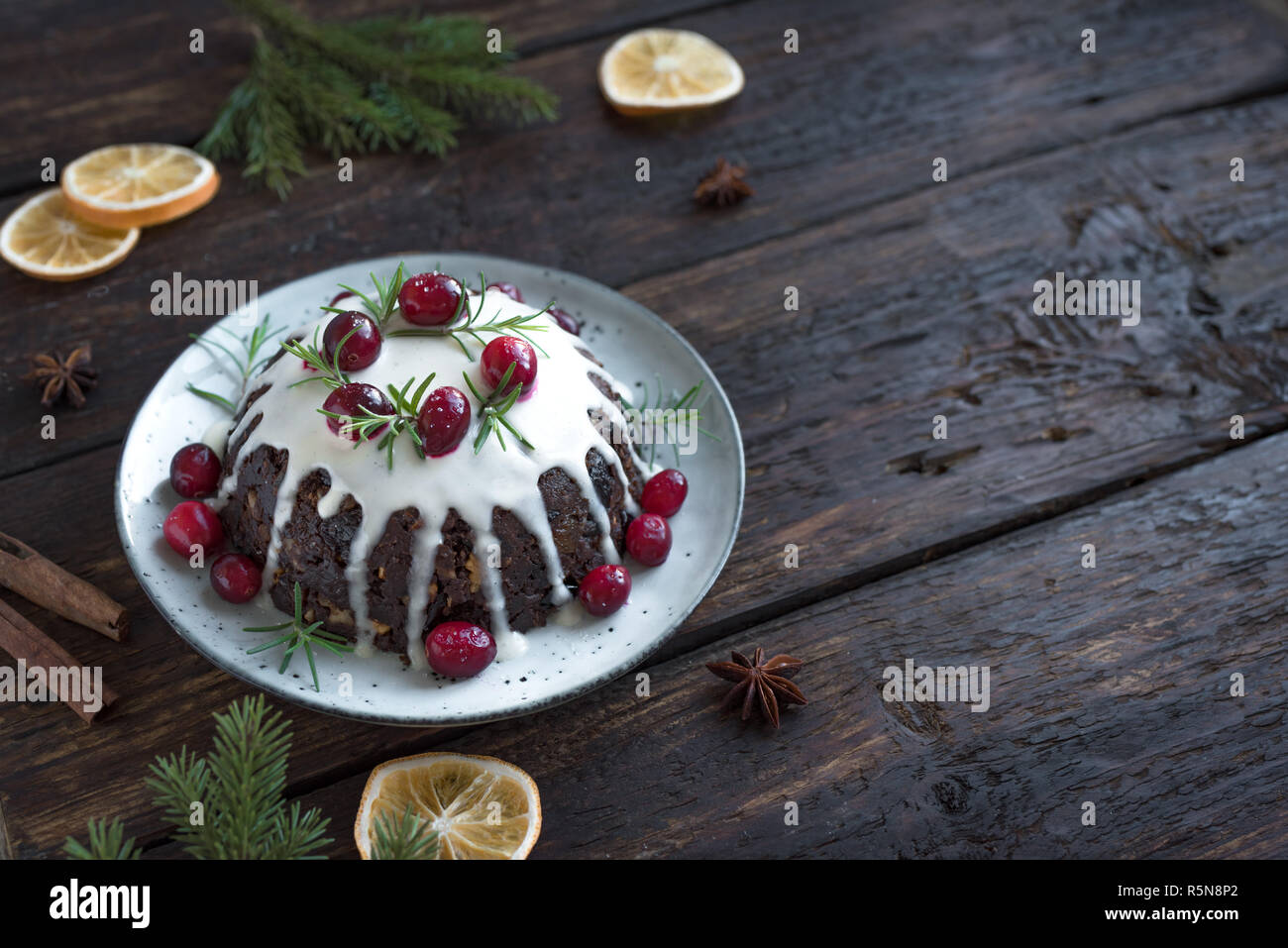 Christmas Pudding, Obst Kuchen mit Puderzucker und Preiselbeeren auf rustikalen Holztisch eingerichtet, Kopieren, Ansicht von oben. Hausgemachte, traditionelle Weihnachten desser Stockfoto