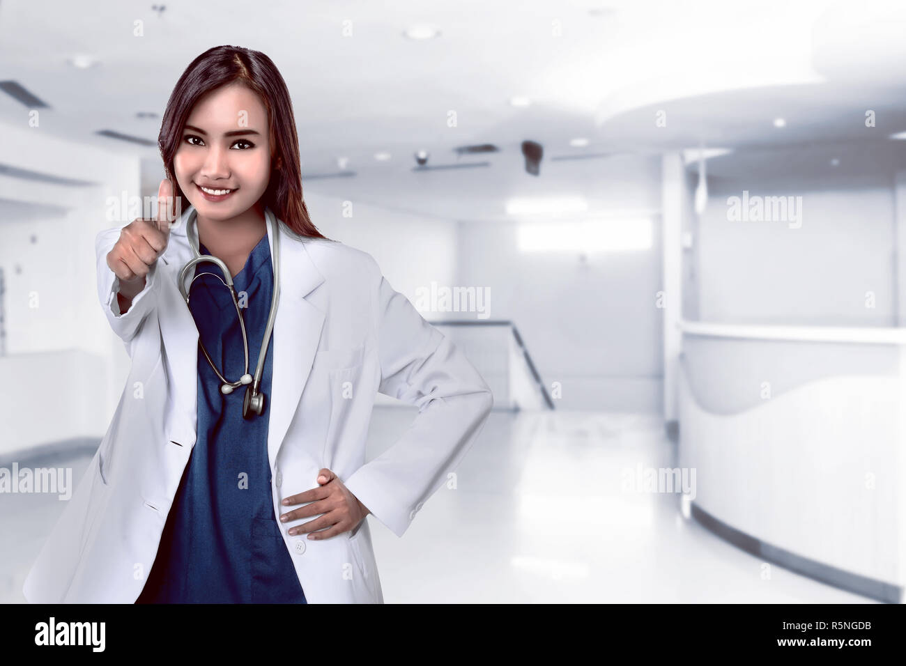 Hübsche asiatische Arzt lächelnd mit Krankenhaus Hintergrund Stockfoto
