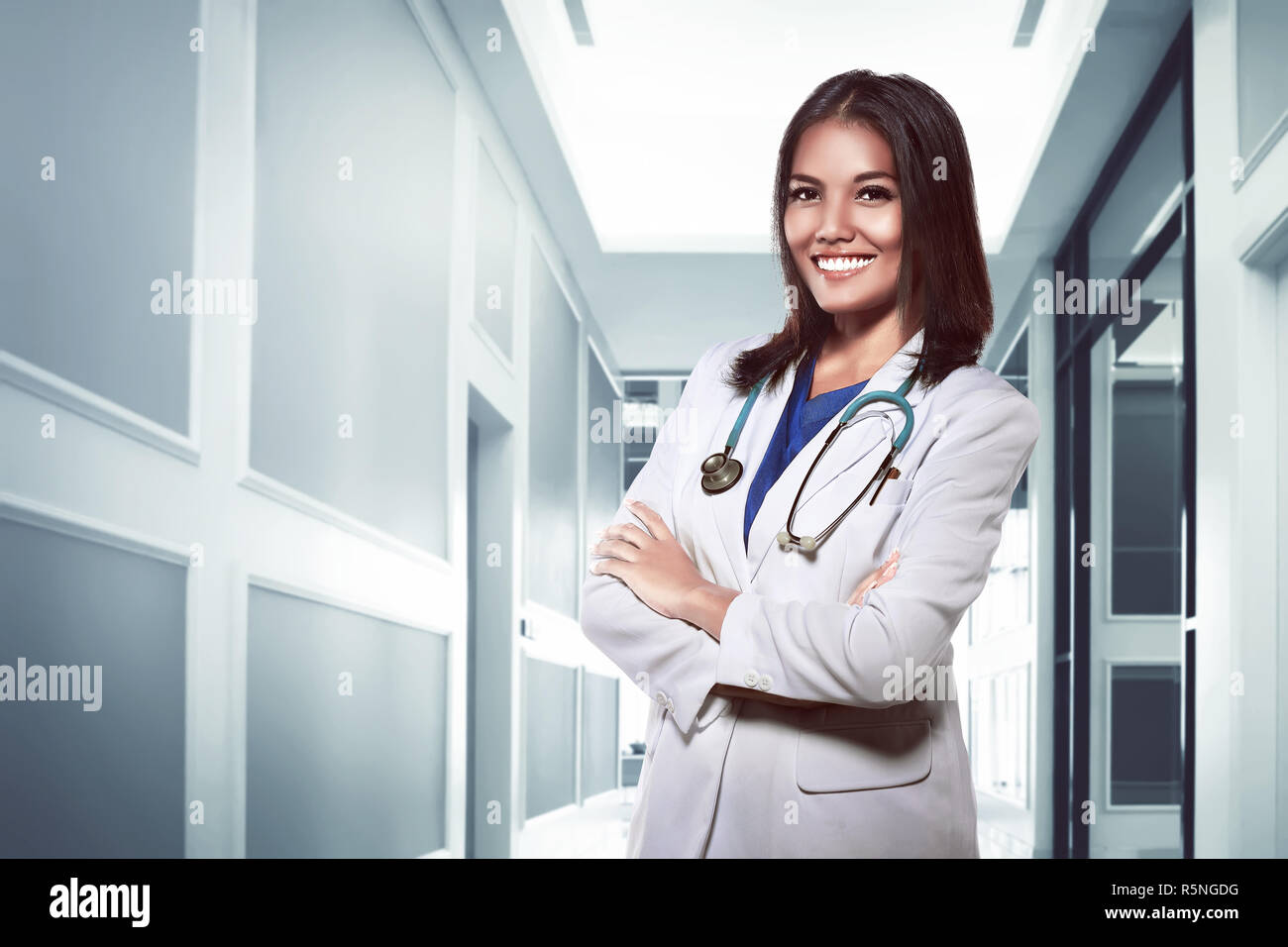 Hübsche asiatische Arzt lächelnd mit Krankenhaus Hintergrund Stockfoto
