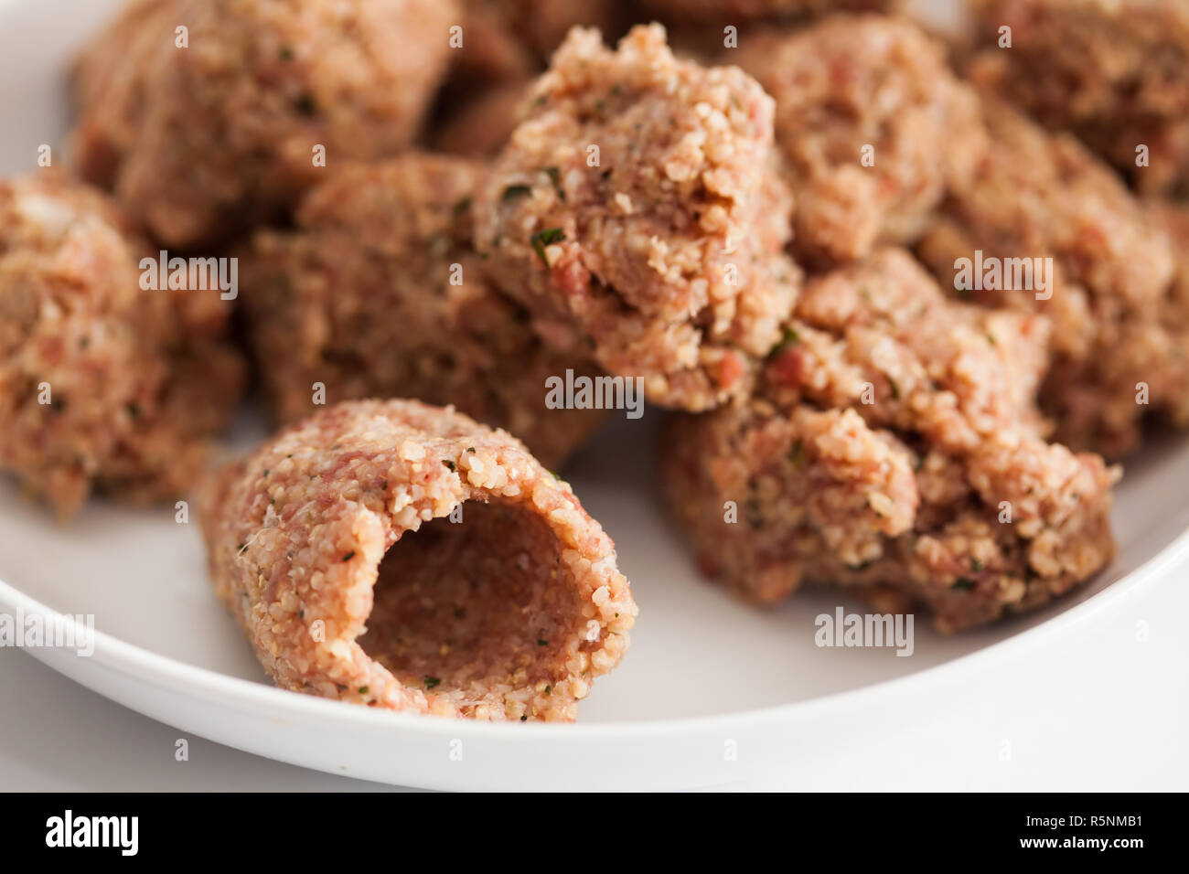 Schritt für Schritt levantinischen Küche kibbeh Vorbereitung: Kugeln kibbeh Fleisch mischen und eine leere kibbeh Stockfoto
