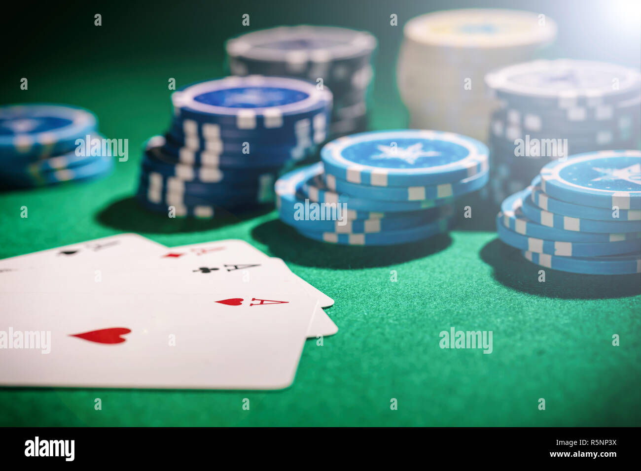 Casino, Glücksspiel Konzept. Vier Asse und poker chips auf grünem Filz Hintergrund Stockfoto