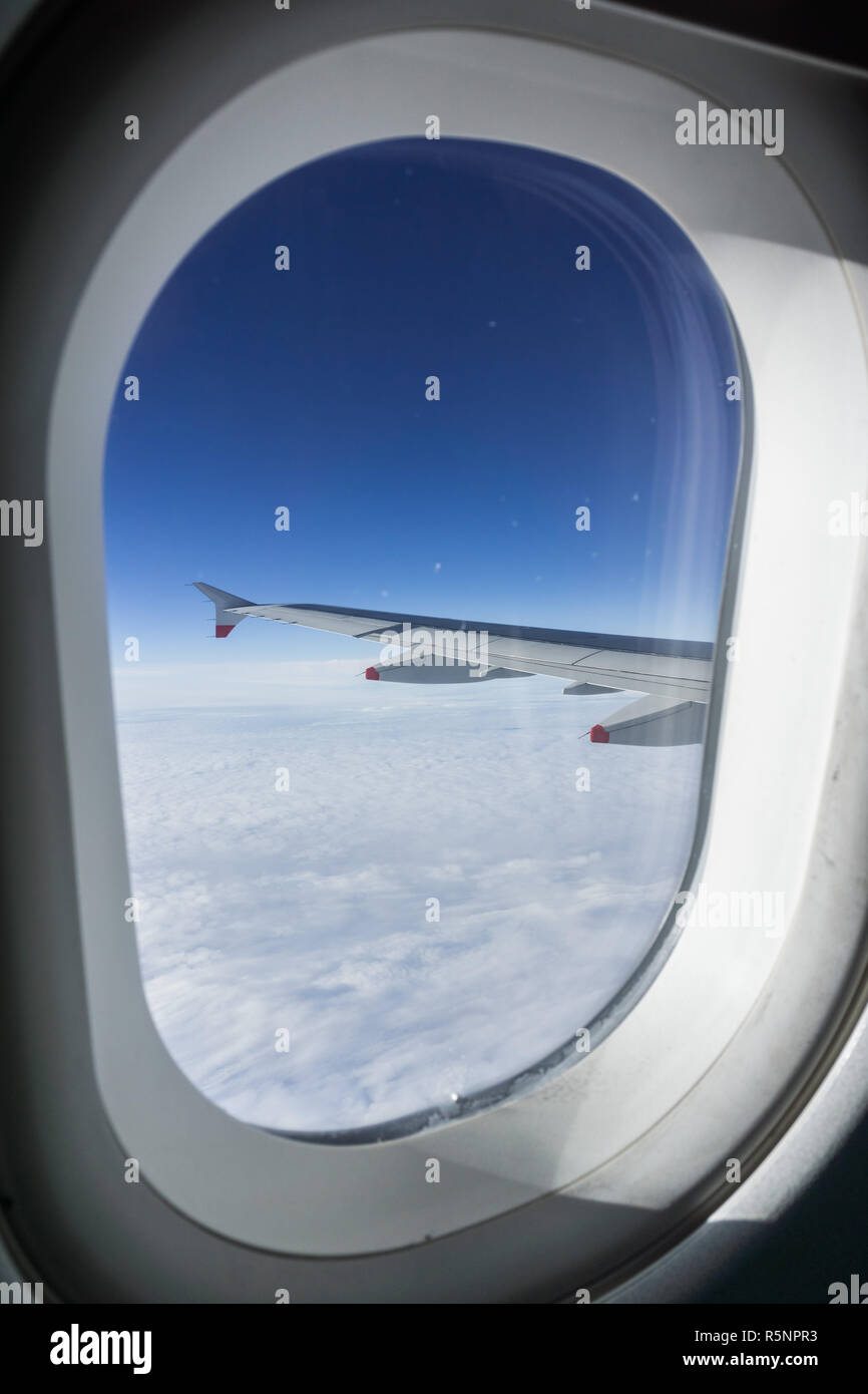 Blick durch das Fenster, während über einem Meer von Wolken fliegen Stockfoto