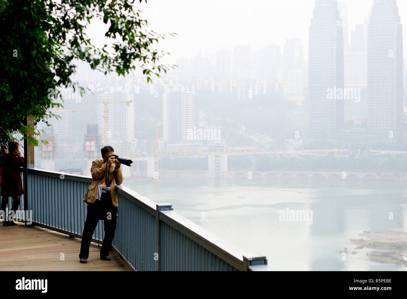 Chongqing, China. 2. Dez, 2018. Ein Mann nimmt Fotos auf der Plank Road entlang der 3 Wanderweg in Yuzhong district Chongqing, im Südwesten von China, Dez. 2, 2018. Seit 2016, lokale Behörde hat Pläne 14 Wanderwege mit einer Gesamtlänge von 39,5 Kilometern zu renovieren gerollt. Die 14 Wanderwege verbinden Chongqing natürliche und kulturelle Highlights Besucher die schönsten und wichtigsten Sehenswürdigkeiten der Stadt. Credit: Liu Chan/Xinhua/Alamy leben Nachrichten Stockfoto