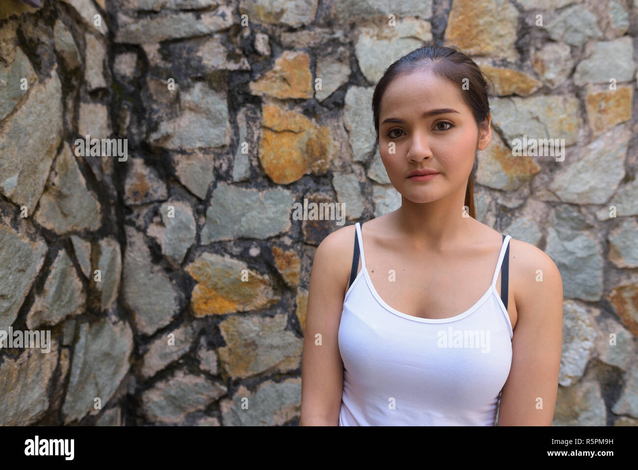 Porträt der jungen schönen asiatischen touristische Frau gegen die Wand Stockfoto