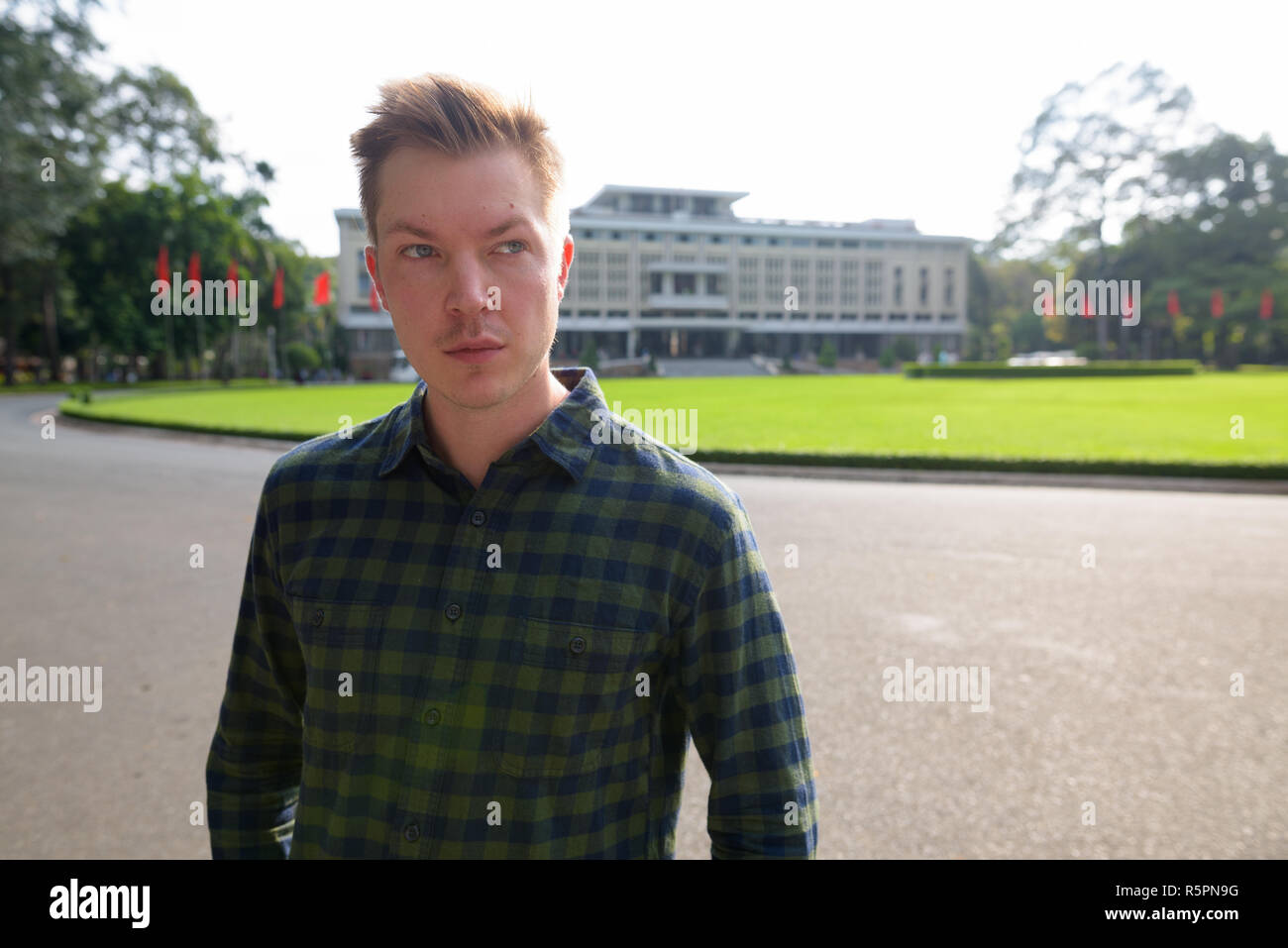 Junge attraktive touristische Mann an Unabhängigkeit museum in Saigon. Stockfoto