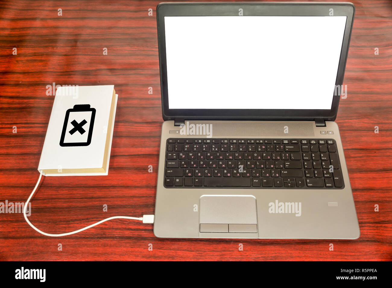 Buchen Sie einem Laptop über ein USB-Ladegerät angeschlossen ist. Das Batteriesymbol zeigt den Ladezustand. Stockfoto