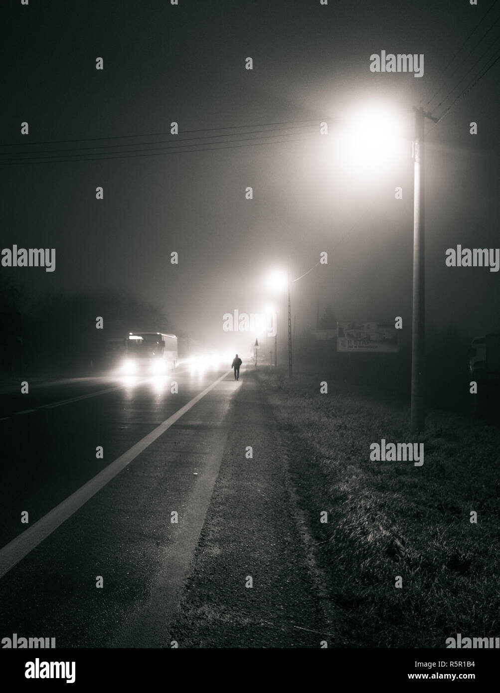 Einsame Mann zu Fuß von der Straße bei Nacht Stockfoto