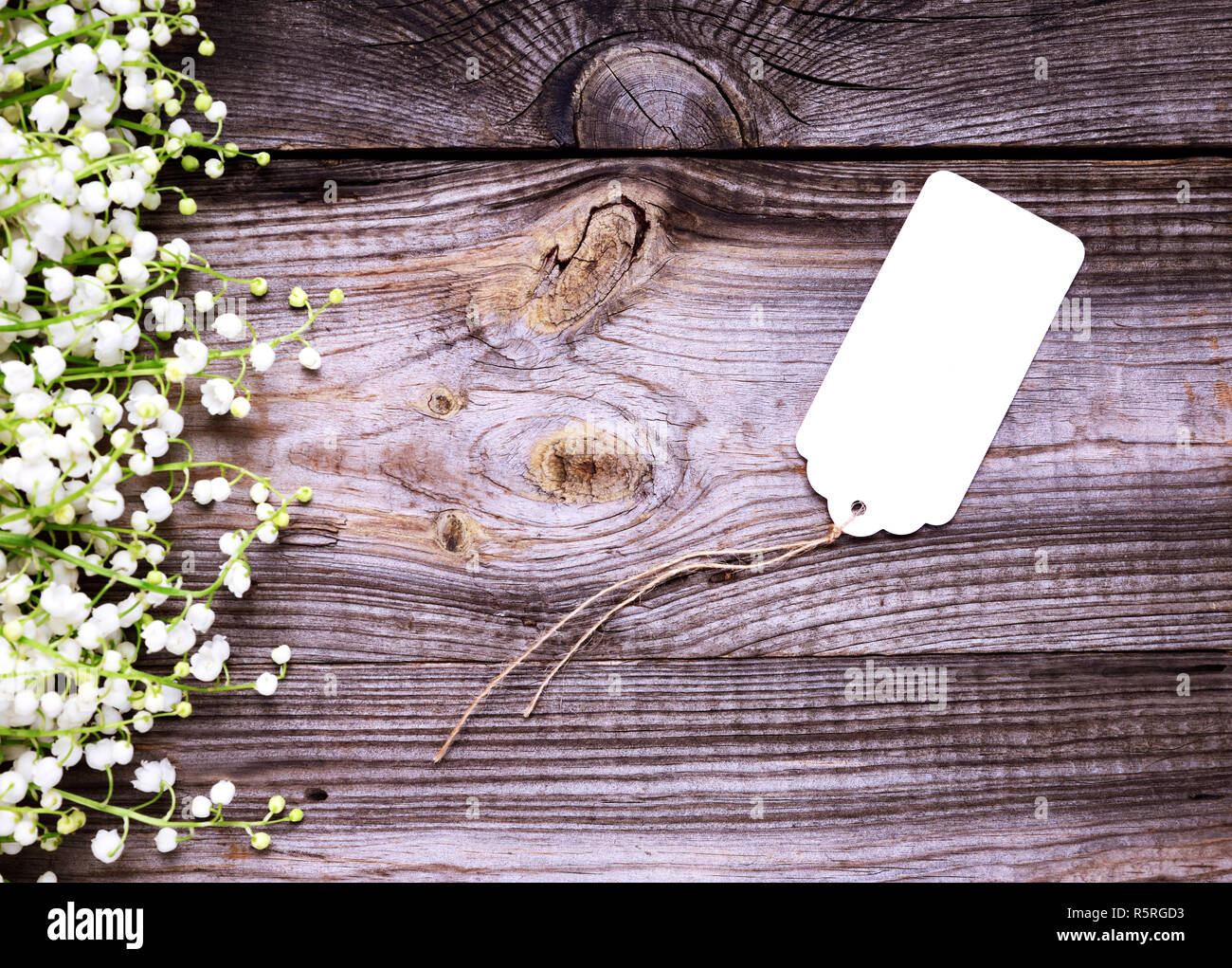 Leeres weißes Papier tag mit einem Seil auf einem grauen Hintergrund Holz Stockfoto