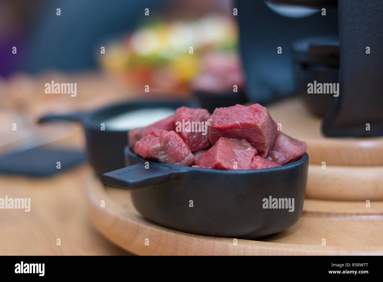 Eine Schüssel mit Rindfleisch in Stücke geschnitten auf einer Holzplatte bereit für Fondue Stockfoto