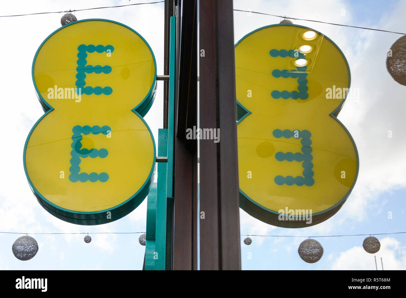 Logo und Beschilderung des EE-Mobilfunkbetreibers außerhalb seines Geschäfts in der Oxford Street, London, England, Großbritannien Stockfoto