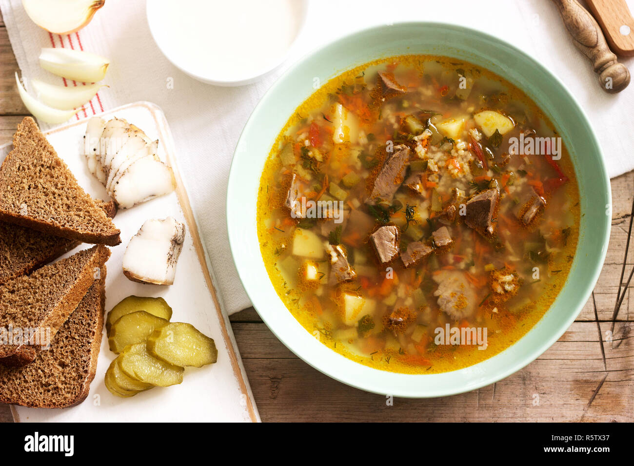 Rassolnik, traditionelle russische Suppe, serviert mit verschiedenen ...