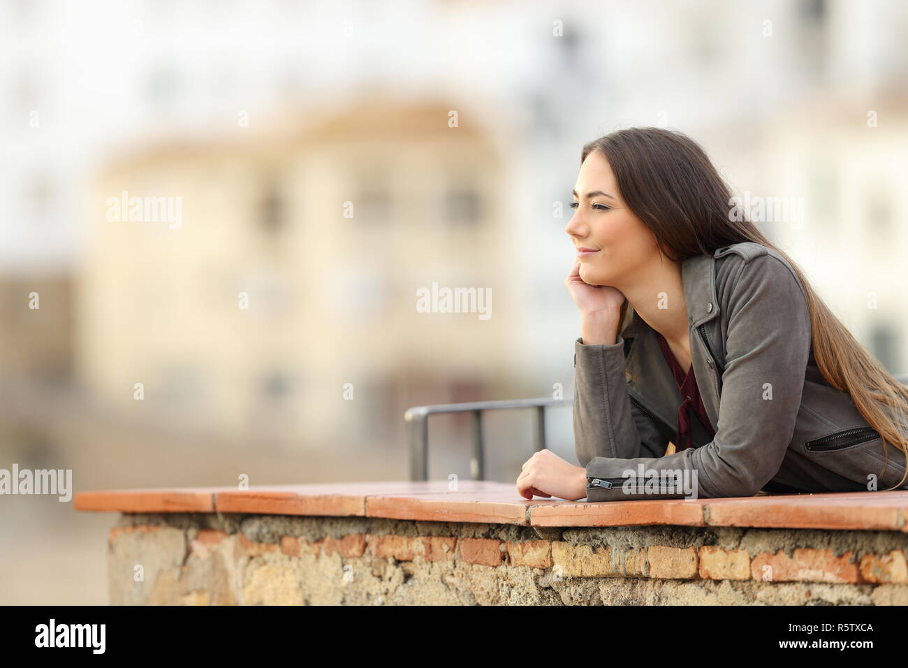 Entspannt Frau betrachten Blick in einen Balkon mit Stadt im Hintergrund Stockfoto