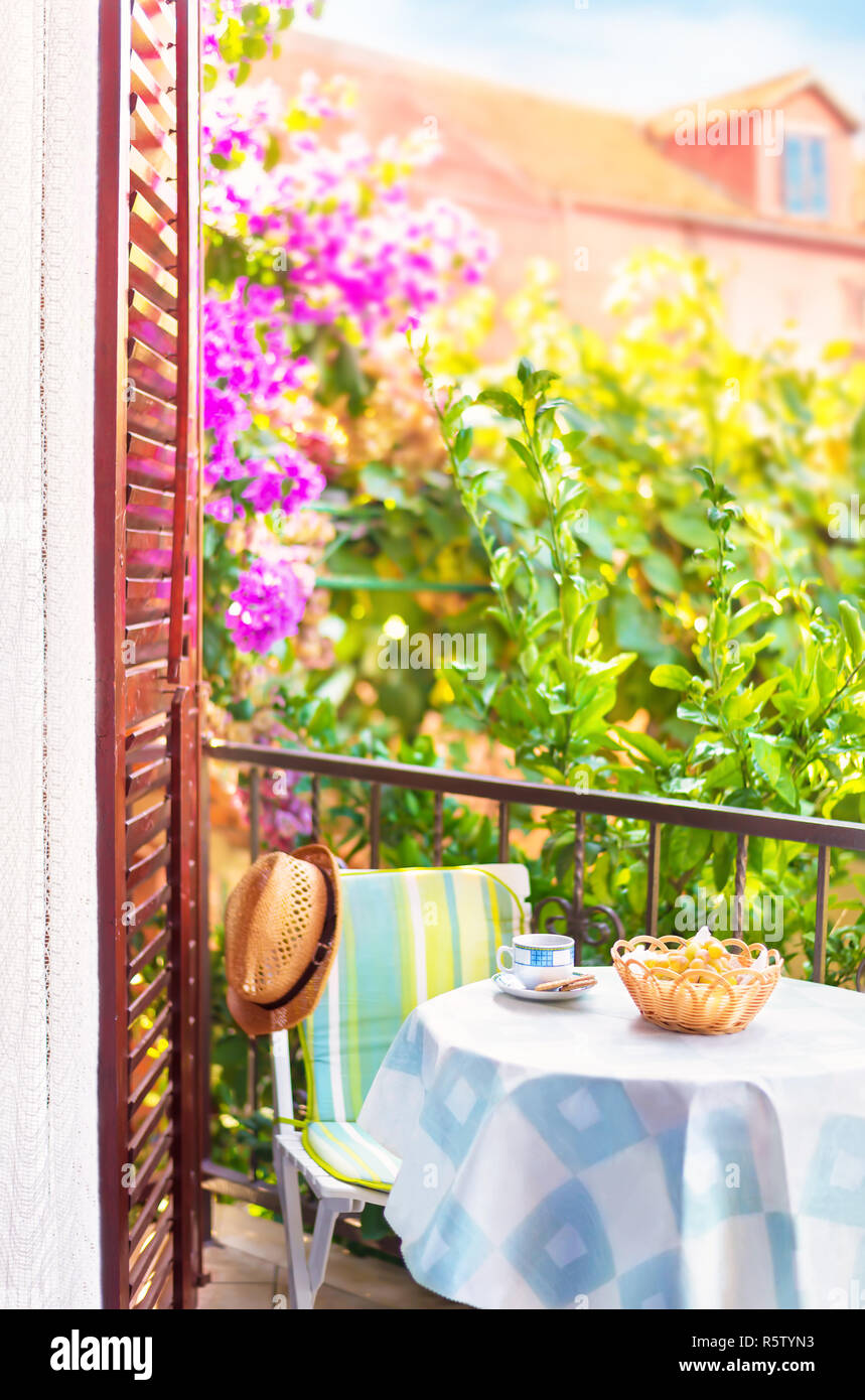 Kaffee und Obst am Balkon Tisch mit Blick auf den Garten auf der sonnigen Sommermorgen in kleinen europäischen Stadt Stockfoto
