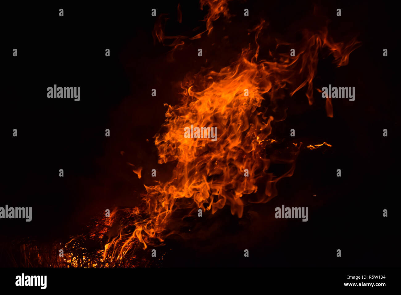 Verbrennung von Stroh von Reis in der Nacht. Red Fire auf einem schwarzen Hintergrund. Die Verbrennung. Stockfoto