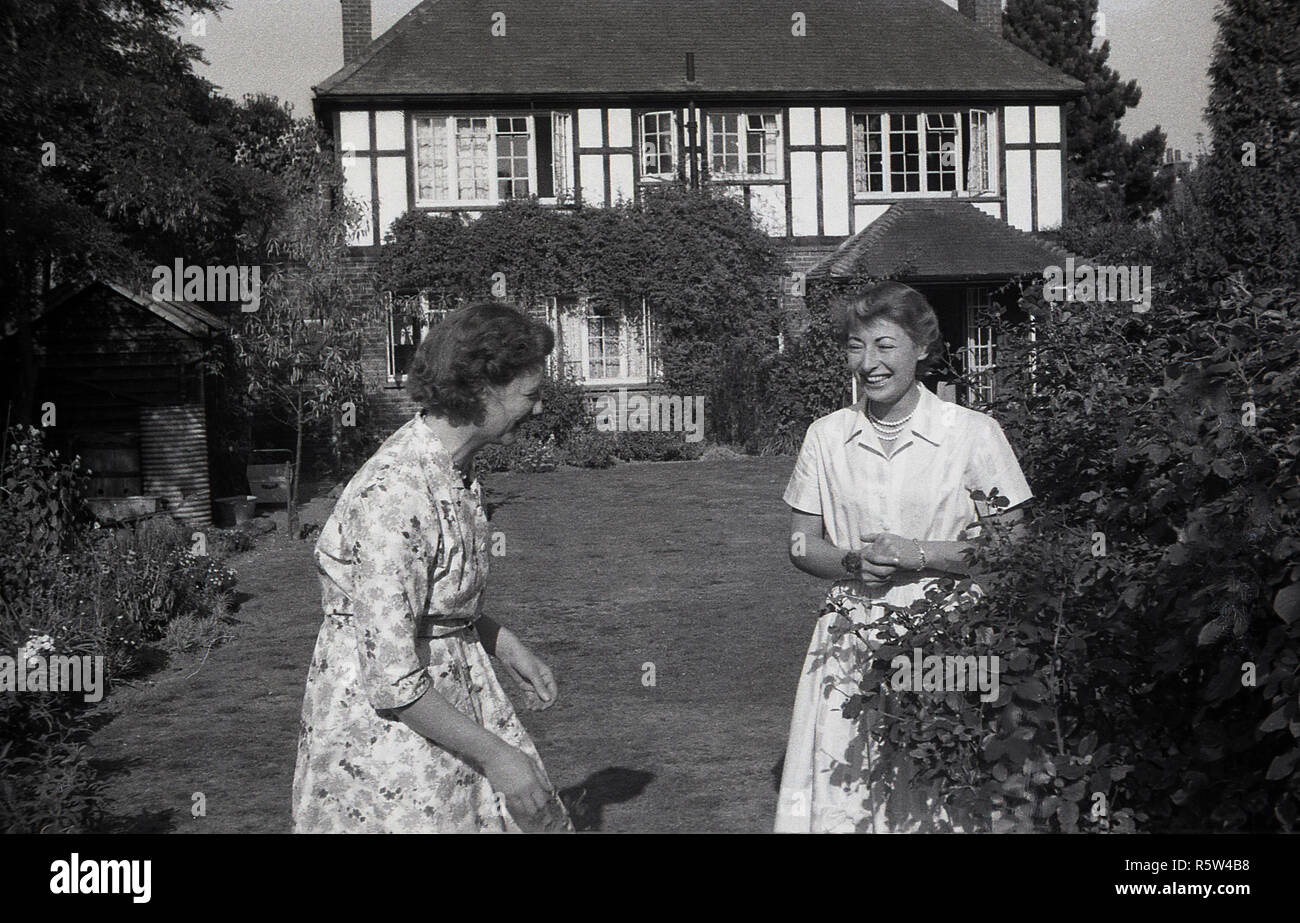 1950, historische, Mutter und Tochter zusammen im Garten eines großen Suburban House, genießt jeder des anderen Firma. Stockfoto