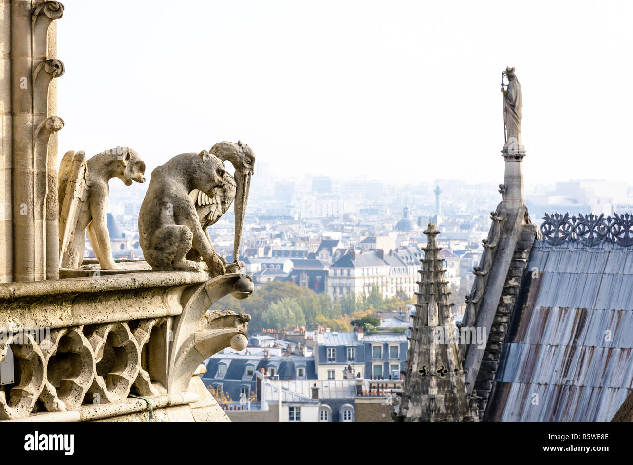 Drei Statuen von Chimären mit Blick auf das Dach der Kathedrale Notre-Dame und dem historischen Zentrum von Paris von den Türmen Galerie mit der Stadt Stockfoto