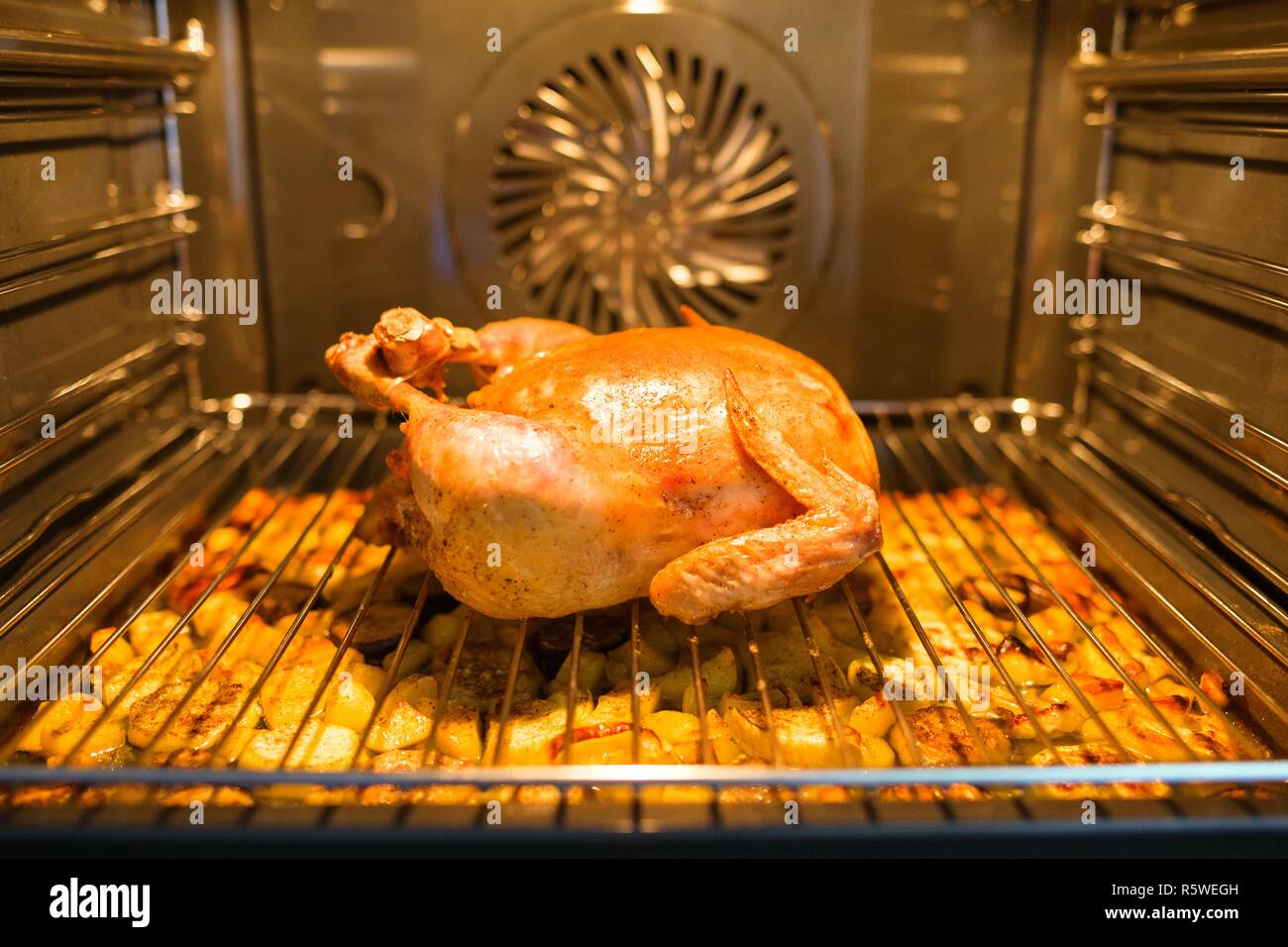 Gebratenes Hähnchen im Ofen auf dem Grill, unter dem Huhn mit  Kartoffelecken Stockfotografie - Alamy