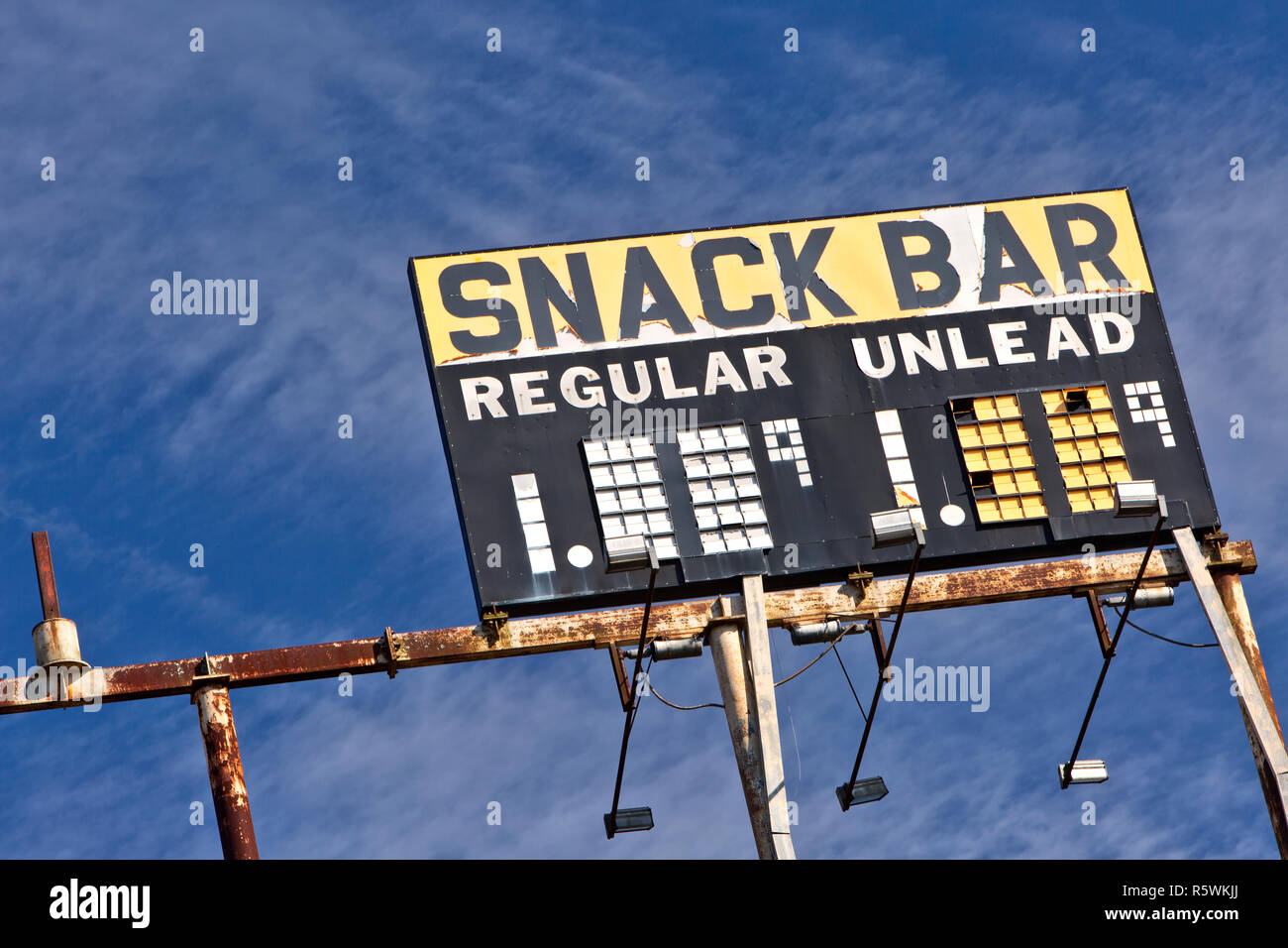 Erhöhte Vintage Gas Station anmelden nack Bar - regelmäßig - Unlead-Benzin, rostigen Metallrahmen, gegen eine verstreute blue sky. Stockfoto