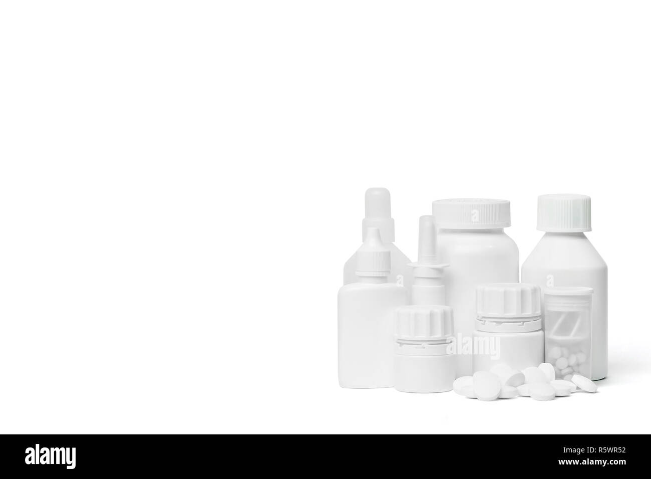 Mehrere sauberen, weißen medizinische Flaschen und einen Stapel Weiße, runde Tabletten auf weißem Hintergrund mit Studio Light Stockfoto