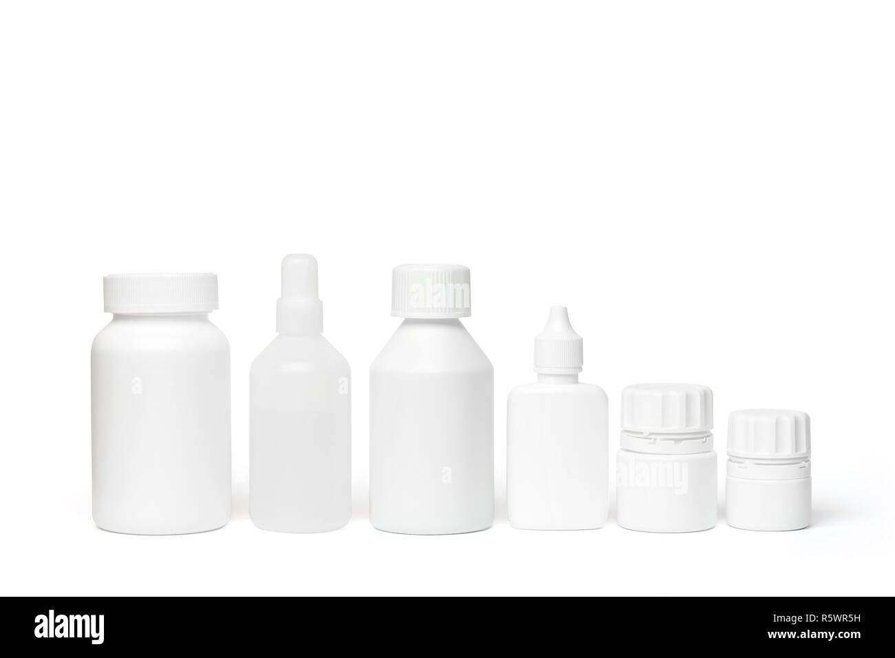 Mehrere sauberen, weißen medizinische Flaschen in einer geraden Linie auf weißem Hintergrund mit Studio Light angeordnet Stockfoto