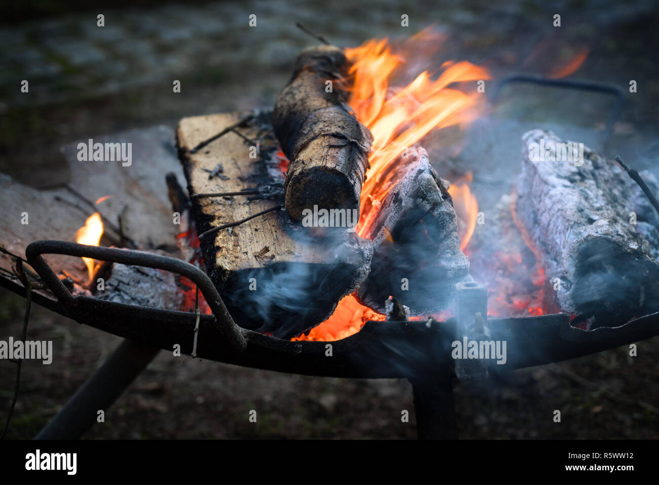 Eisen Feuerschale mit brennenden Rundholz erwärmt sich bei Open Air Veranstaltungen auf kalte Nächte, Kopieren, Schwerpunkt ausgewählt, enge Tiefenschärfe Stockfoto