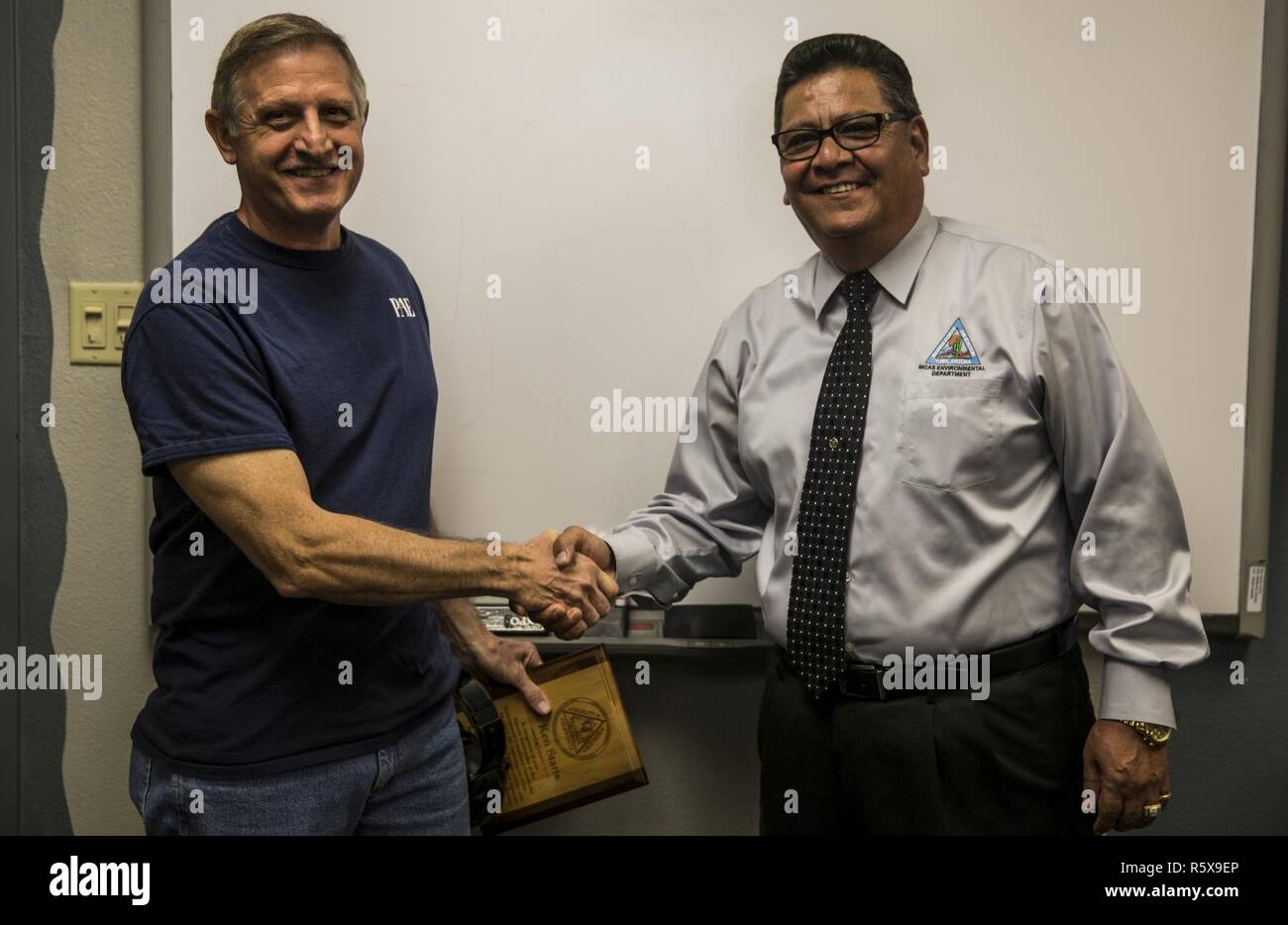 David Rodriguez, der Direktor des Marine Corps Air Station Yuma, Arizona, Environmental Department, gratuliert Kenneth beginnt, die Einhaltung von Umweltvorschriften Koordinator mit VMFT-401, für seine überragende Leistung von Abgaben, Dienstag, 18. April 2017. Beginnt verwaltet 46 benannten Abfallströme, 746 Artikel von gefährlichen Stoffen und konsequent erhält herausragende Marken mit keine Diskrepanzen auf seine Umwelt Compliance Jahresinspektionen. Stockfoto