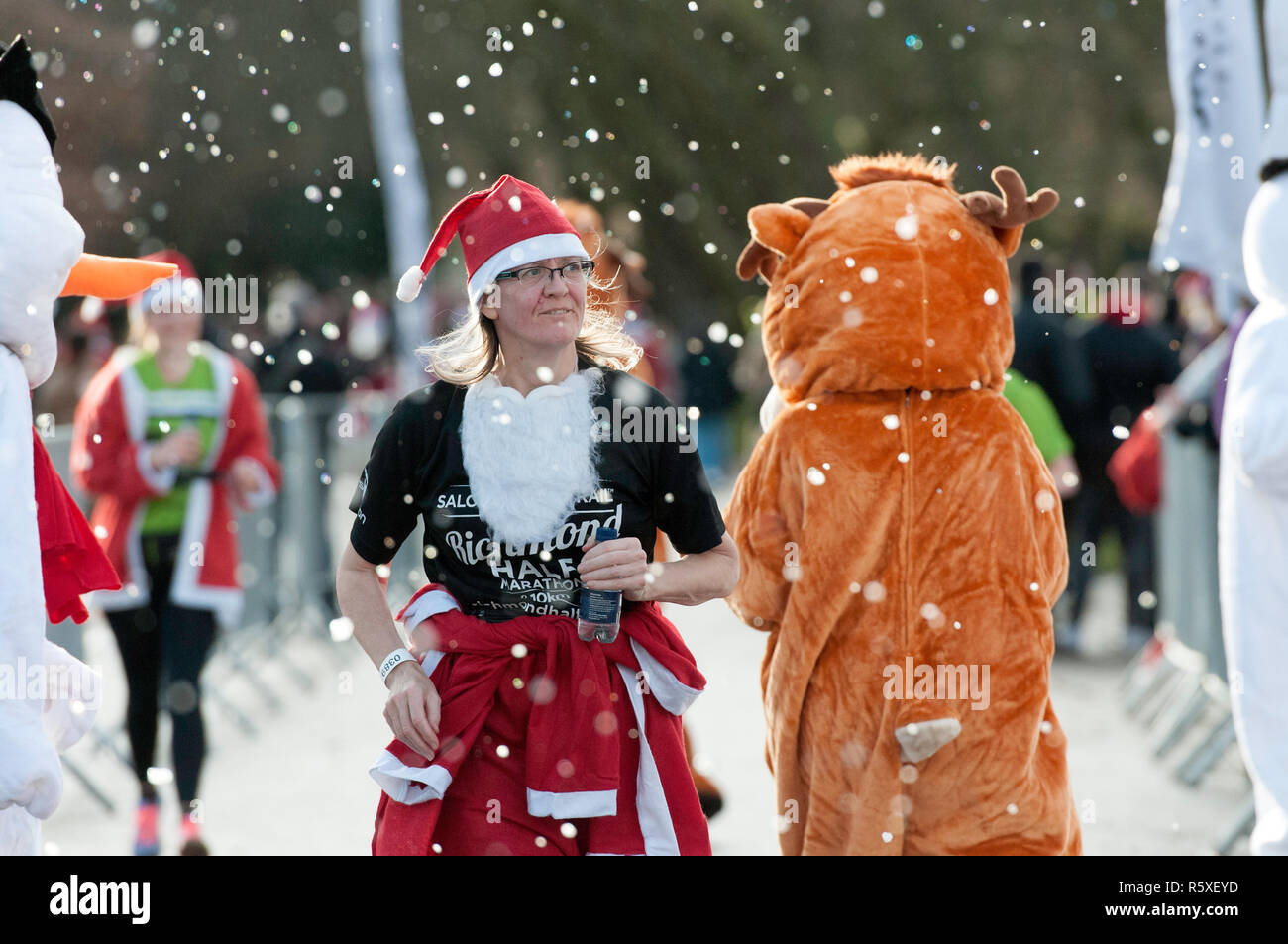 Ein Teilnehmer in einem Santa Kostüm gesehen an einem Teilnehmer an einem Tiger Kostüm während des Laufs gekleidet. Läufer verkleidet als Weihnachtsmann in einer großen Run im Victoria Park teil. Die Teilnehmer hatten die Wahl zwischen 5 km und 10 km Strecke durch den Park und der Zweck der Veranstaltung war es, Geld für verschiedene Wohltätigkeitsorganisationen zu erhöhen. Stockfoto