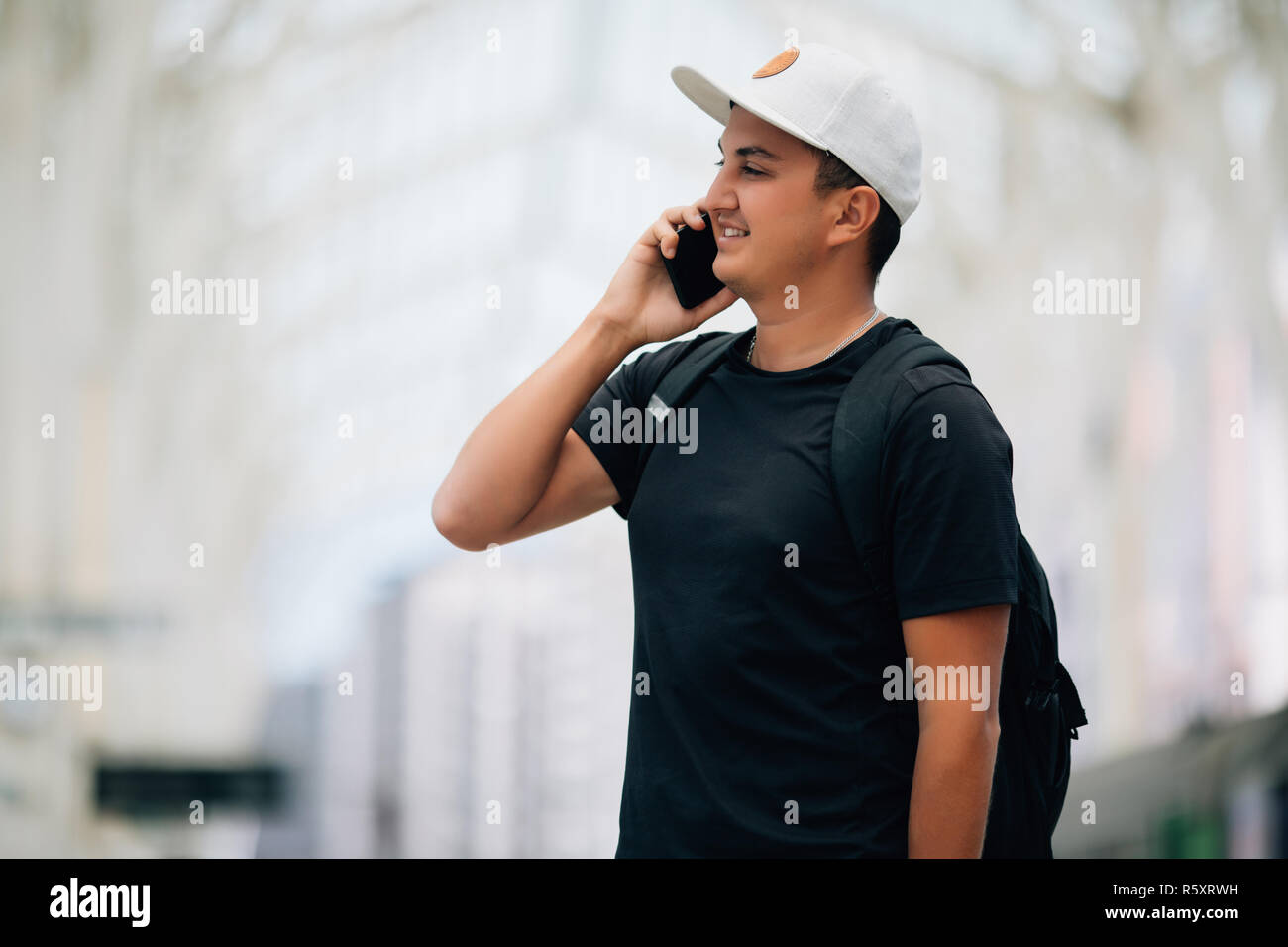 Junger Mann mit dem Rucksack am Bahnhof, Reisende Stockfoto