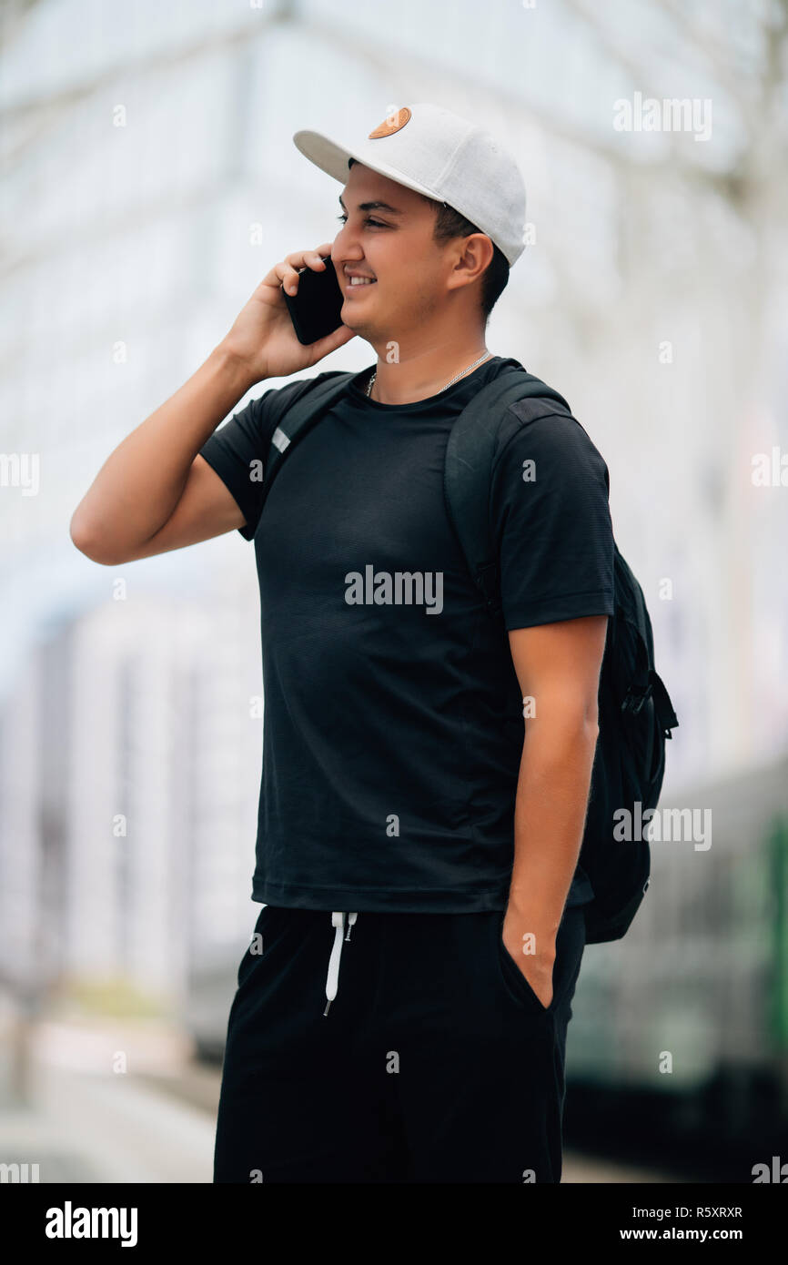 Junger Mann mit dem Rucksack am Bahnhof, Reisende Stockfoto