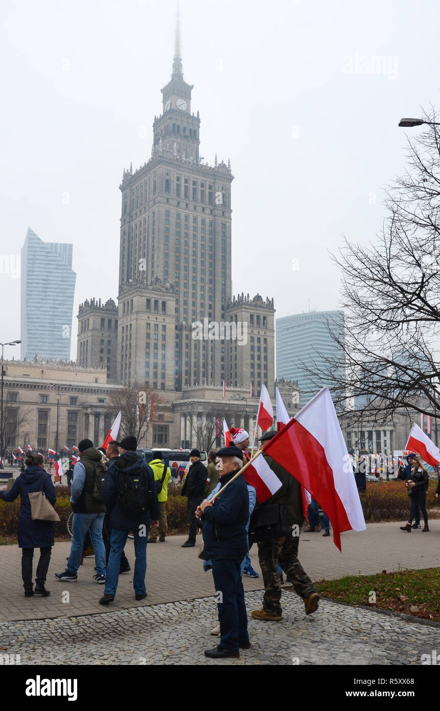 Ein Mann hält eine polnische Flagge vor dem Palast der Kultur, der nationalen Unabhängigkeit Tag März, 100 Jahr Jubiläum, Warschau, Polen, 11. November 2018 Stockfoto