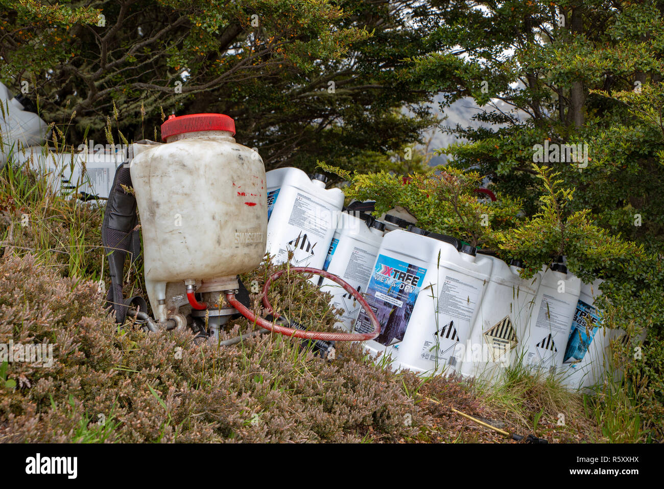 Canterbury, Neuseeland - 3. Dezember 2018: Kunststoffbehälter von Herbizid eingesetzt zu töten wilding Kiefern sind per Hubschrauber auf einen Hügel geliefert Stockfoto