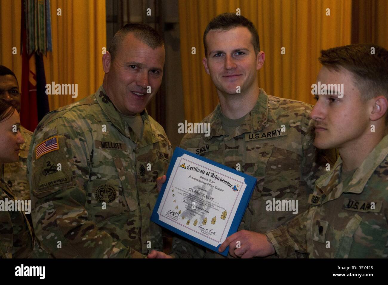 Command Sgt. Maj. Bret A. Mellott, der obersten Führer der Joint Multinational Readiness Center in Deutschland angeworben, präsentiert Cpl. Riley Schwan, ein 45th Infantry Brigade Combat Team Soldat, der mit einem Zertifikat für sein sehr ehrt Absolvent der 7th Army Training Befehl Noncommissioned Officer's Academy Basic Leader Kurs 704-17 am Yavoriv Combat Training Center auf dem internationalen Friedens und der Sicherheit, in der Nähe der Yavoriv, Ukraine statt, am 22. April. Stockfoto