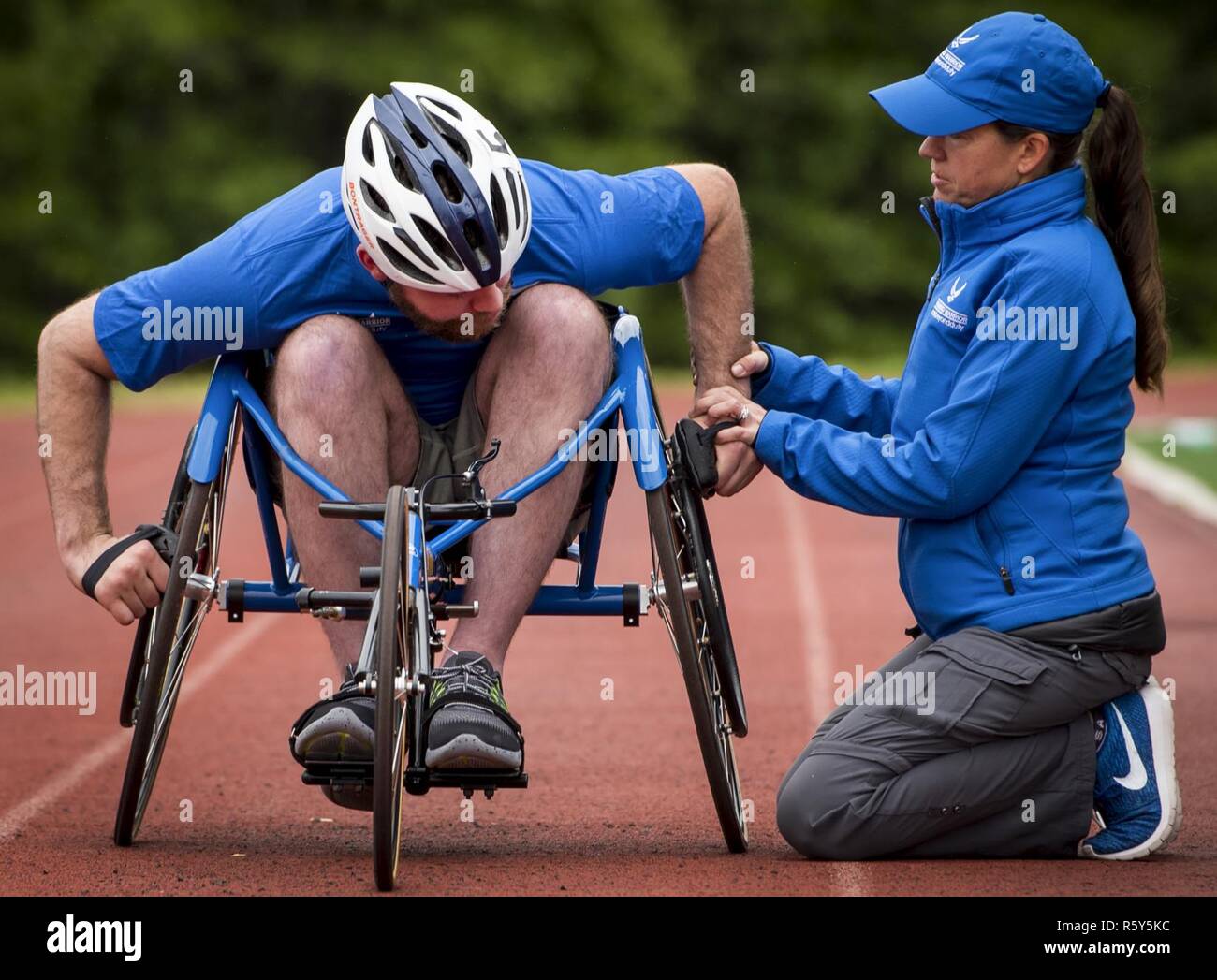 Airman 1st Class John Lemoine, ein Krieger spiele Athlet, erhält etwas Hilfe bei seinen Sport Stuhl von Teresa Skinner, ein Krieger Spiele Trainer, während einer morgendlichen Leichtathletik Session im Trainingslager der Air Force Team der Eglin Air Force Base, Fla., am 24. April. Die base-hosted, einwöchigen Krieger spiele Training Camp ist das letzte Team Training vor dem jährlichen Wettbewerb im Juni. Stockfoto