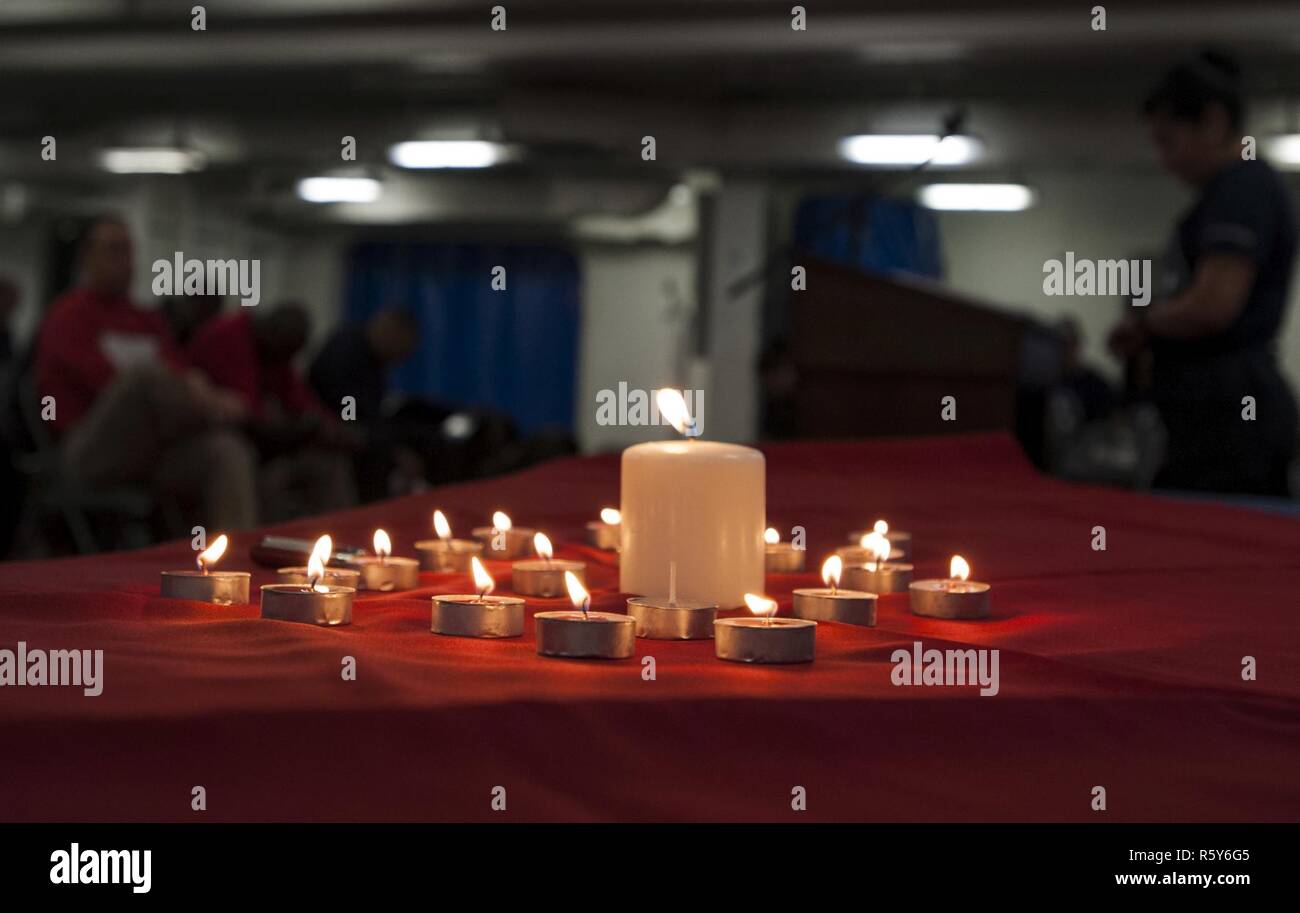 Arabischen Golf (24. April 2017) Segler beobachten, ein Moment der Stille, in der Erinnerung an den Holocaust Veranstaltung an Bord der Flugzeugträger USS George H.W. Bush (CVN 77) (GHWB). GHWB ist in den USA der 5. Flotte Bereich für Maßnahmen zur Erhöhung der Sicherheit des Seeverkehrs auf die Verbündeten und Partnern zu beruhigen bereitgestellt, und der Freiheit der Schiffahrt und des freien Handels in der Region erhalten. Stockfoto