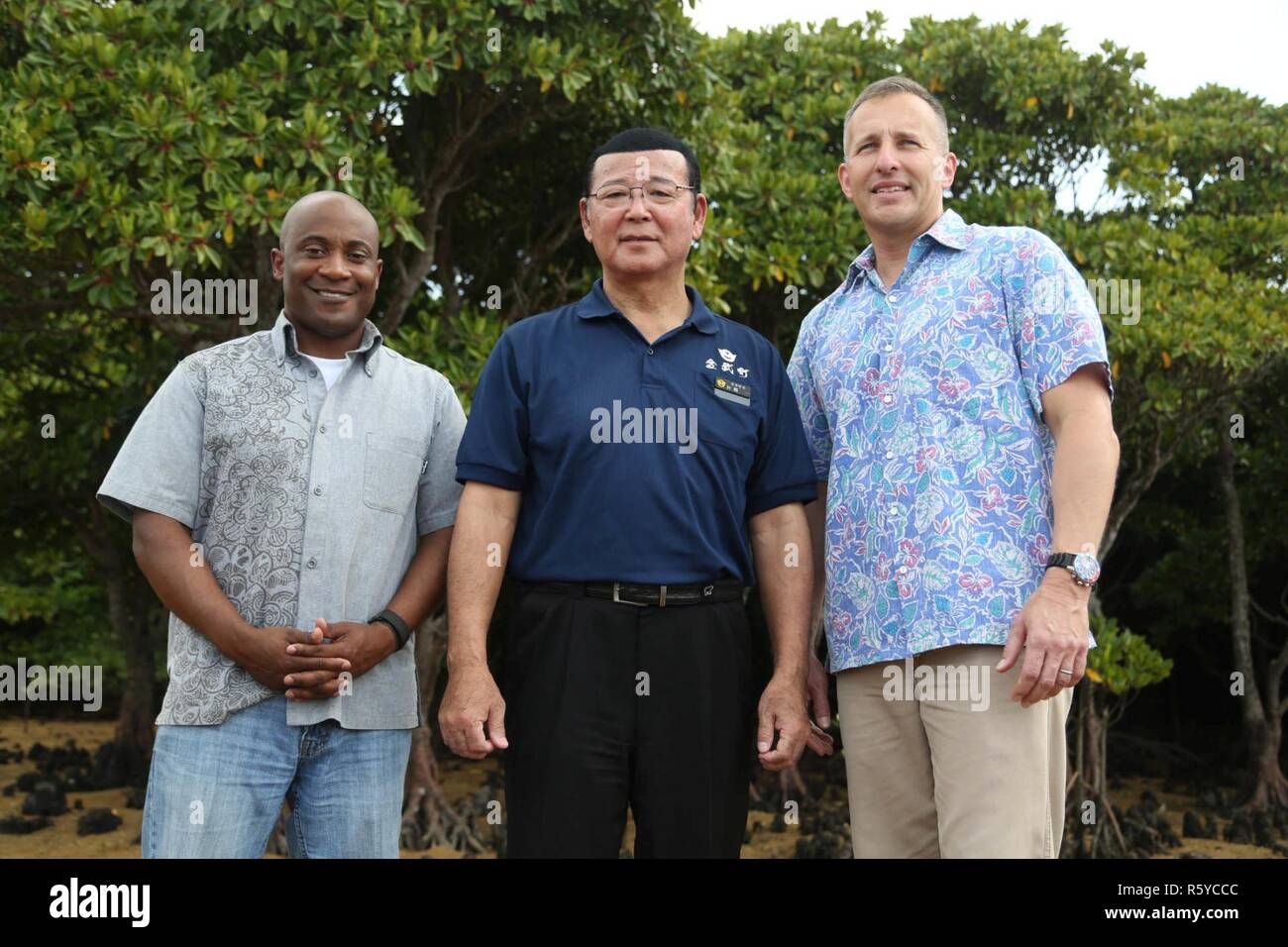 Von links nach rechts, Sgt. Maj. Mario Felder, Bürgermeister Hajime Nakama und Oberst Brian Howlett posieren für ein Foto bei Natur Mirai Kan am 21. April in Kin Stadt, Okinawa, Japan. Natur Mirai Kan in Kin Stadt, Okinawa, Japan. Rund 100 Teilnehmer, die den Abfall entlang der Okukubi Fluss und pflanzte Mangrove Setzlinge Neben dem Flussbett. Felder ist Sergeant Major des 3. Marine Expeditionary Force Headquarters Group. Nakama ist der Bürgermeister von Kin der Stadt. Howlett ist das Camp Hansen Kommandanten und kommandierender Offizier der 3. Marine Expeditionary Force Headquarters Group. Stockfoto