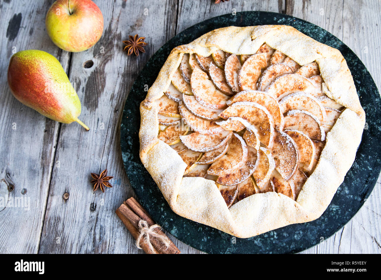 Kuchen mit Äpfeln, Birnen und Zimt auf einem alten hölzernen Hintergrund Stockfoto