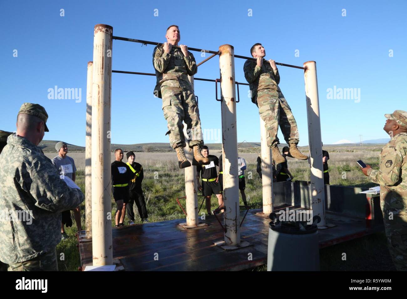 U.S. Army Command Sgt. Maj. Kenneth Graham (links), 20 CBRNE Command Sergeant Major und Sgt. 1. Klasse Jason Rumpf (rechts), CBRNE Führer Kurs Noncommissioned Officer verantwortlich, führen Sie den Gebeugten Arm für die Bundeswehr Proficiency Abzeichen in Yakima Training Center, Washington, April 21, 2017 hängen. Die gebogenen Arm hängen in einer der drei Veranstaltungen in der Basic Fitness Test, in dem die Teilnehmer aufgefordert sind, ihre Kinn über der Bar für mindestens fünf Sekunden zu halten. Stockfoto