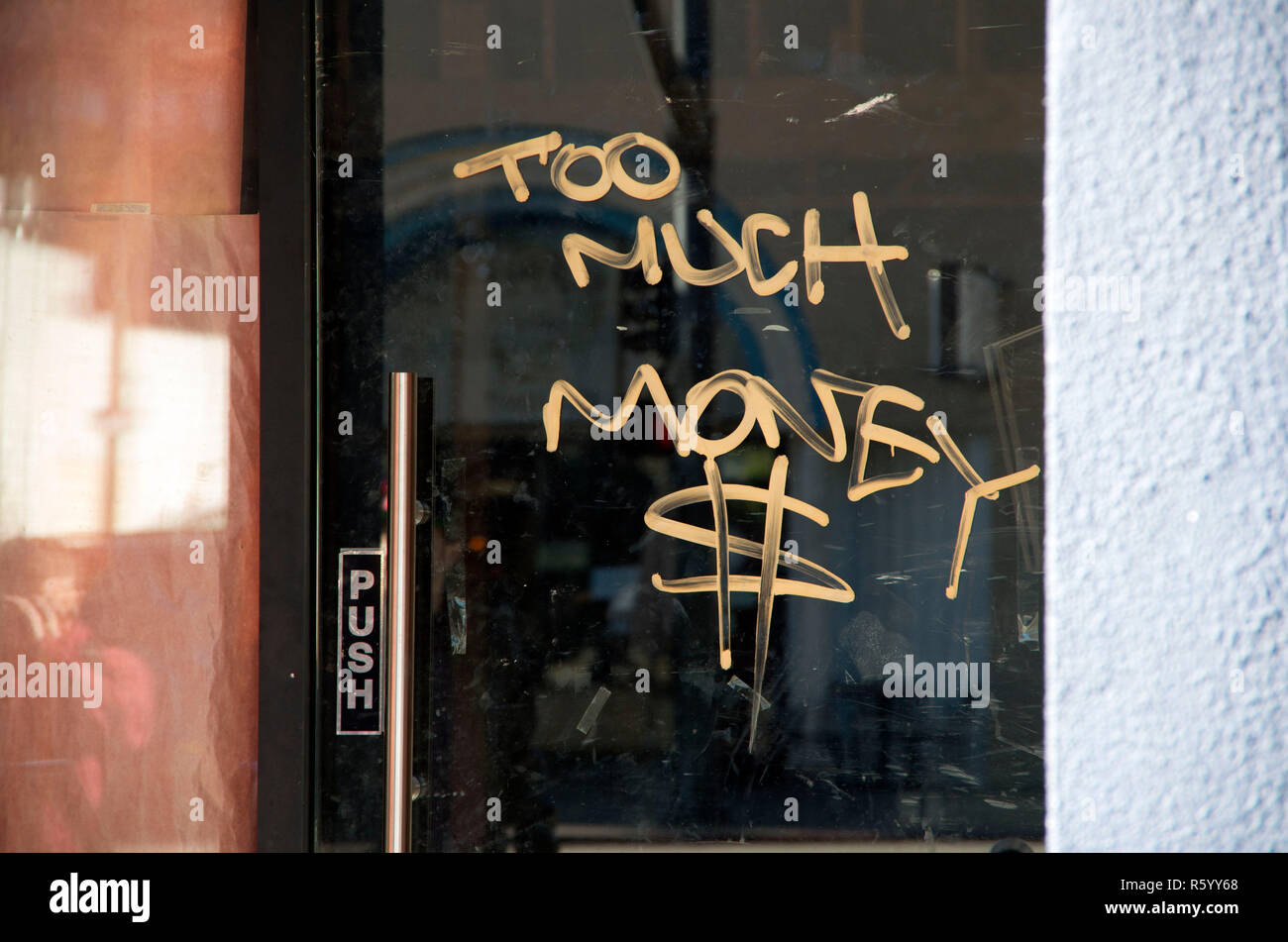 Ein Spray-painted Nachricht auf eine Glastür in Oakland, CA. Stockfoto